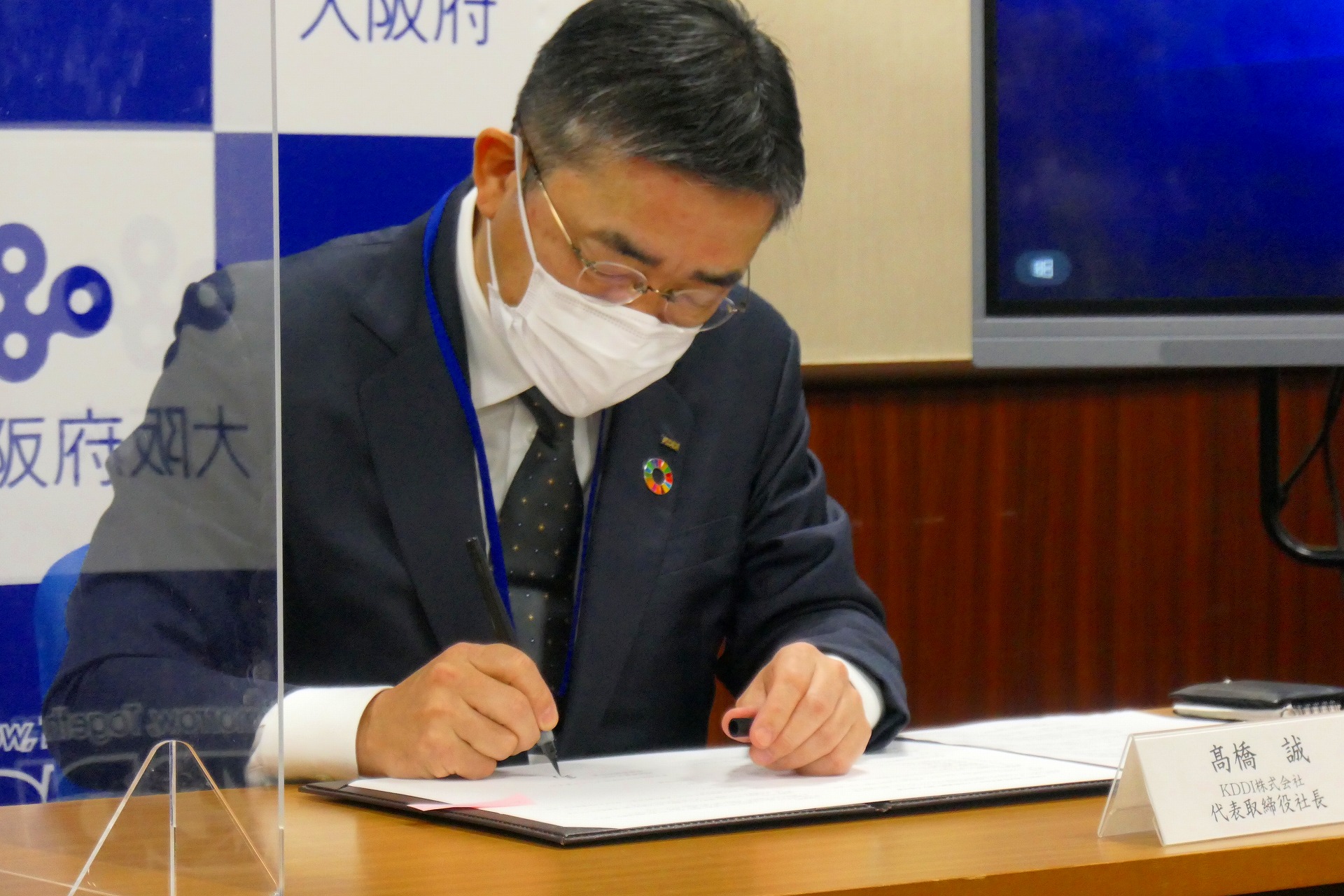 締結書に署名する髙橋社長