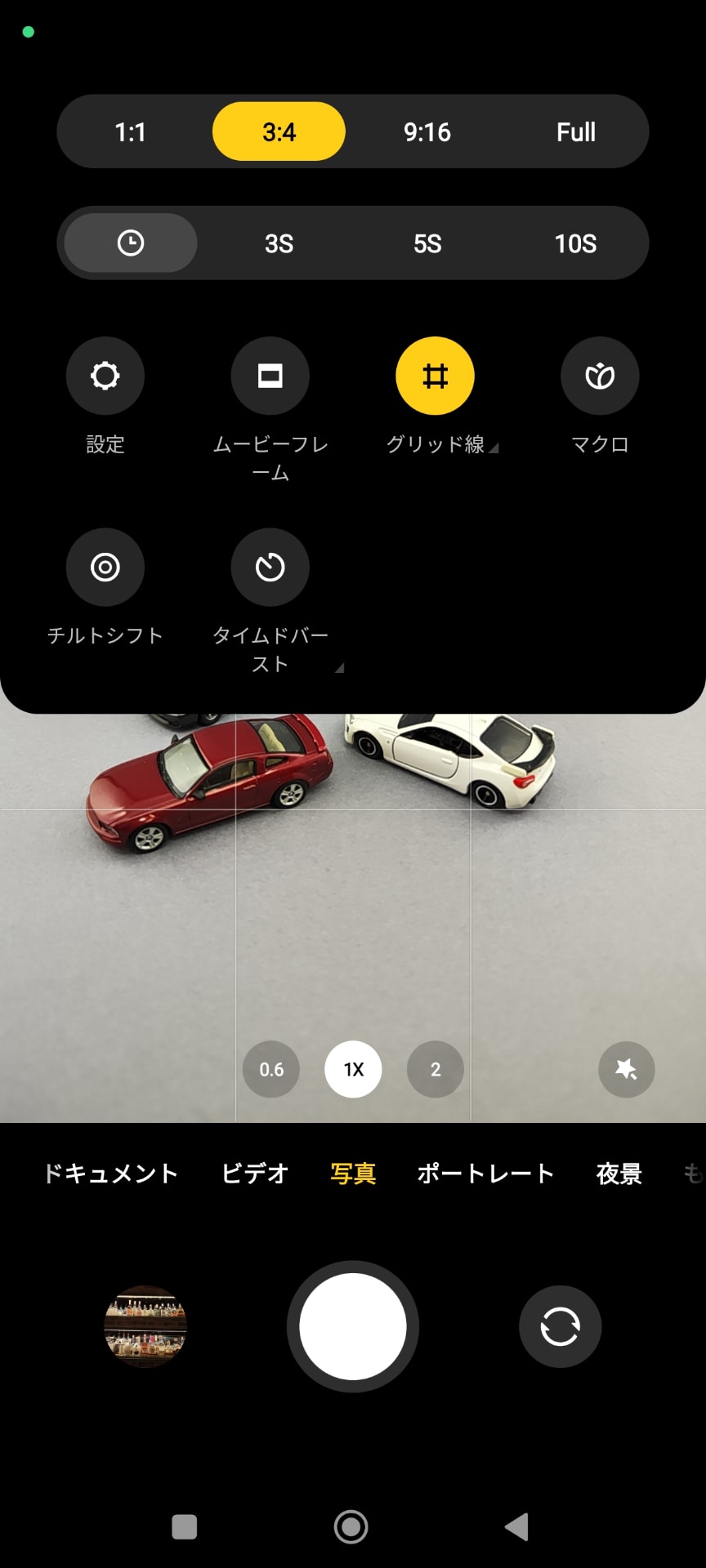 ［カメラ］アプリを起動し、右上のメニューをタップすると、アイコン表示の設定メニューが表示される。画面は［写真］モードの設定メニュー。三段目の［設定］をタップすると、［カメラ設定］の画面が表示される