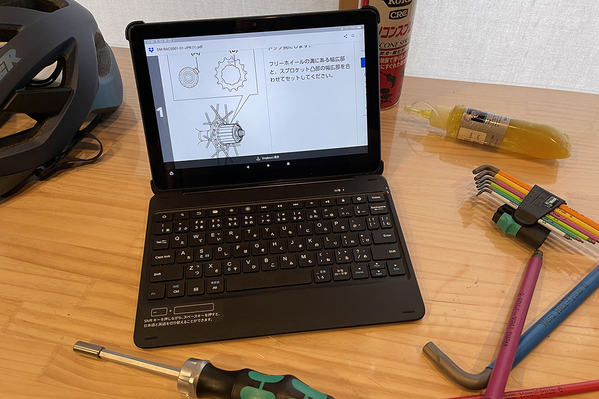 自転車のメンテナンス中にFire HD 10を使うの図。「グリスが少し付いた指で画面を操作」みたいな、普通はまずしないコトもヤレちゃったりする。「ヒッ、ヒドイ！」（Fire HD 10の声）