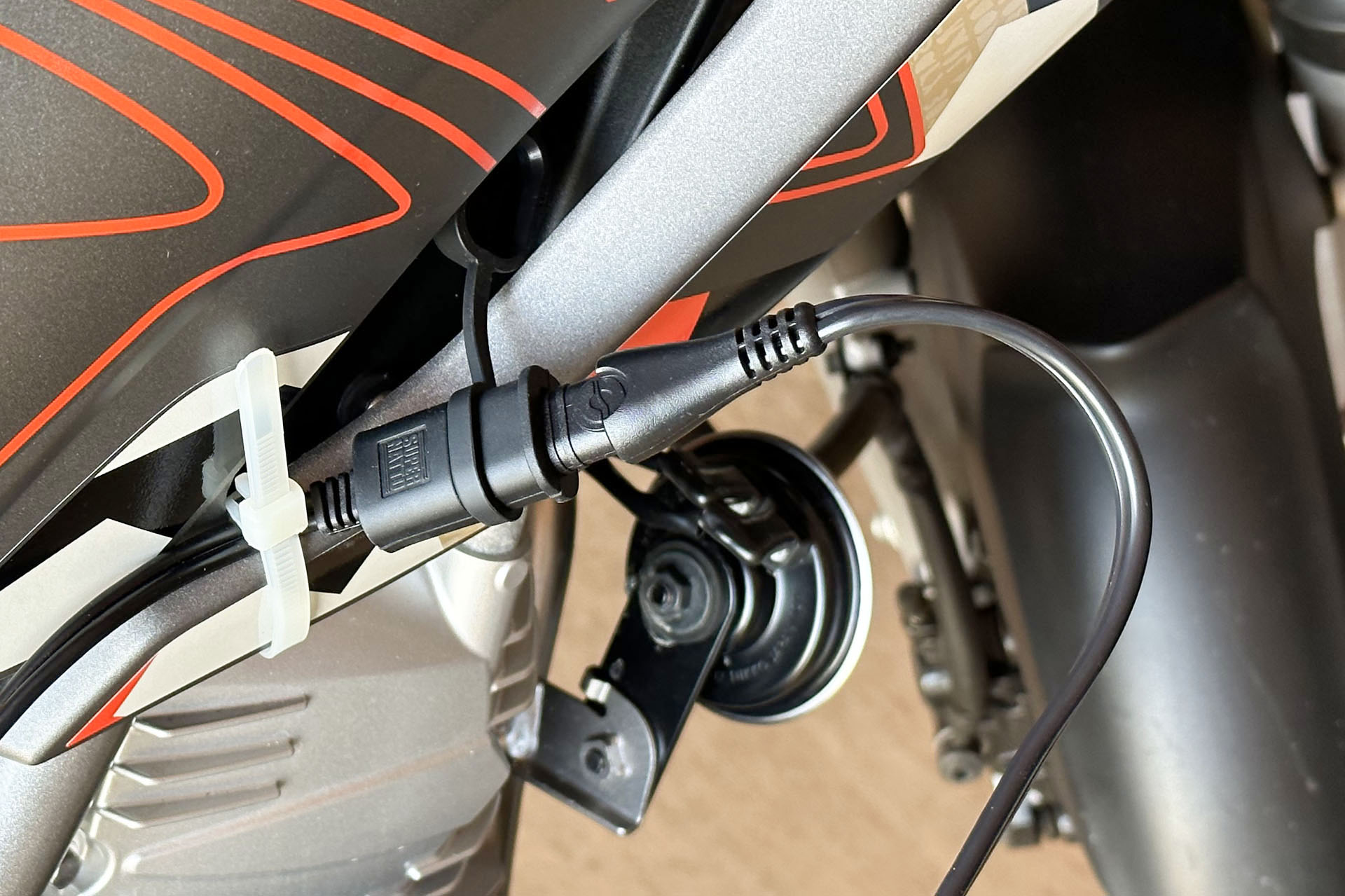 モーターサイクル側には12Vバッテリーにつながったコネクターを出している。充電時にはオプティメイトから伸びるケーブルをここにつなぐだけでOK。