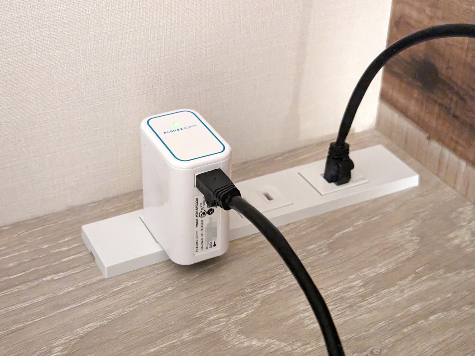 実際にビジネスホテルに設置した状態。コンセントに直接挿せれば場所を取らず便利だが、左右に干渉したり、コンセントを占有してしまう問題もある