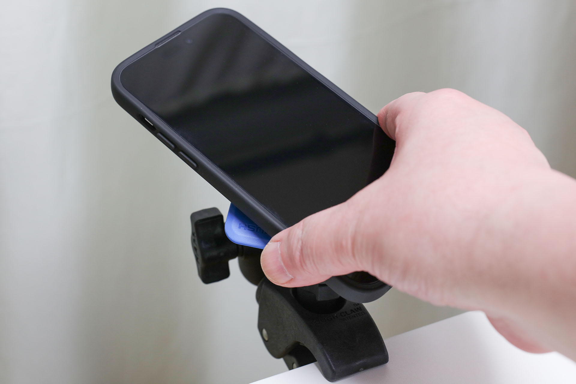 マウントへ端末を装着。まず端末を45°傾けてマウントへ押し当てる。