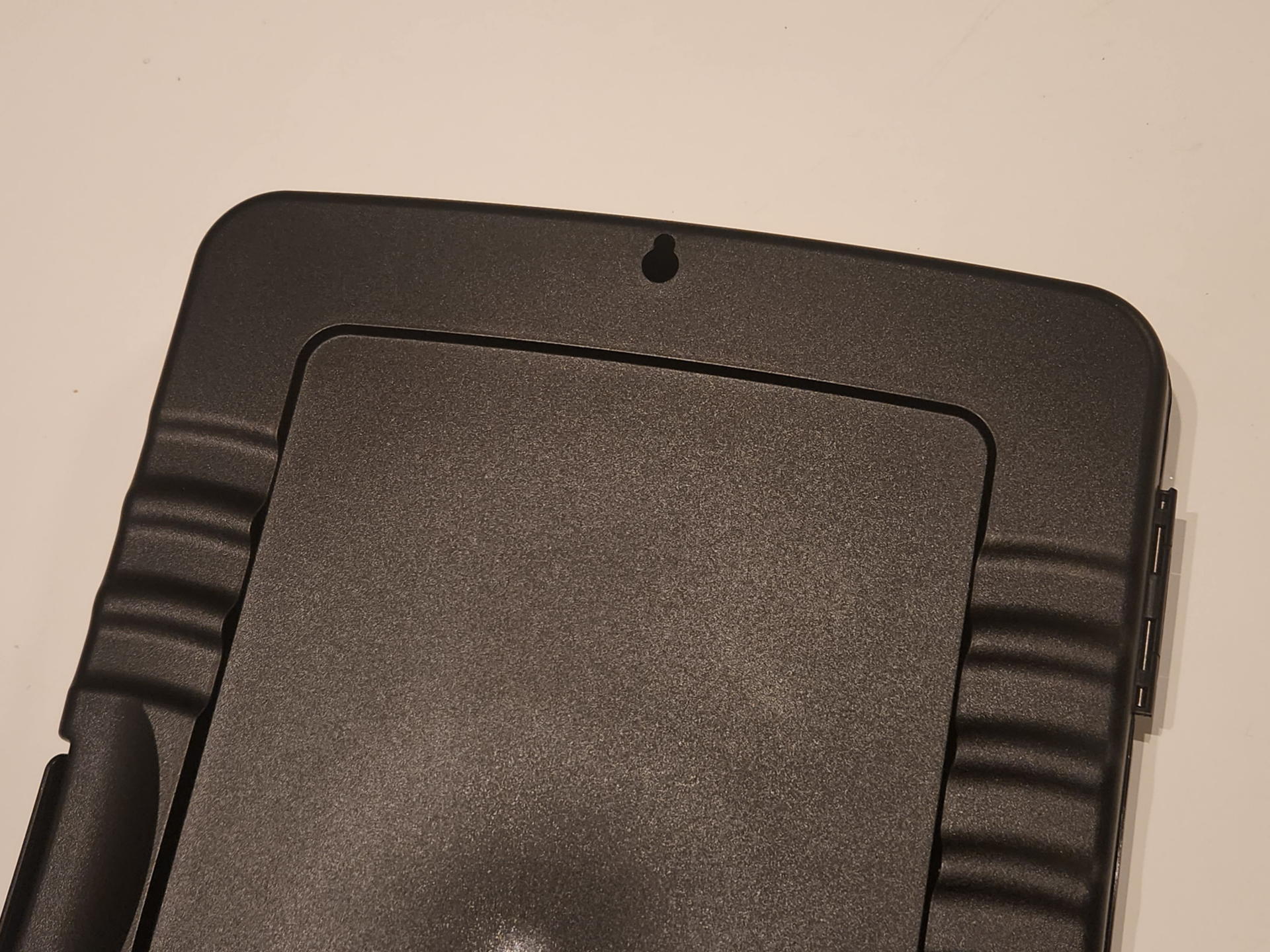 クリップボードフォルダは厚さ30mmなので普通に手持ちができる。滑らないように背面各所に指先の引っかかる凹面部分が多数用意されている。ハンギングのために丸穴もある。