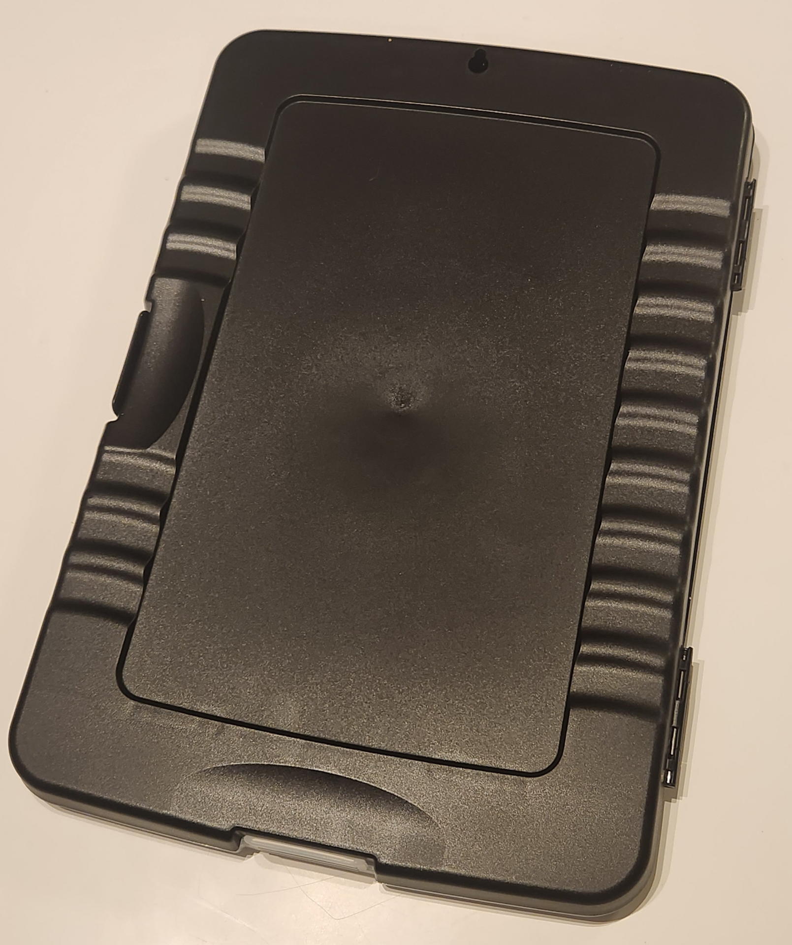 クリップボードフォルダは厚さ30mmなので普通に手持ちができる。滑らないように背面各所に指先の引っかかる凹面部分が多数用意されている。ハンギングのために丸穴もある。