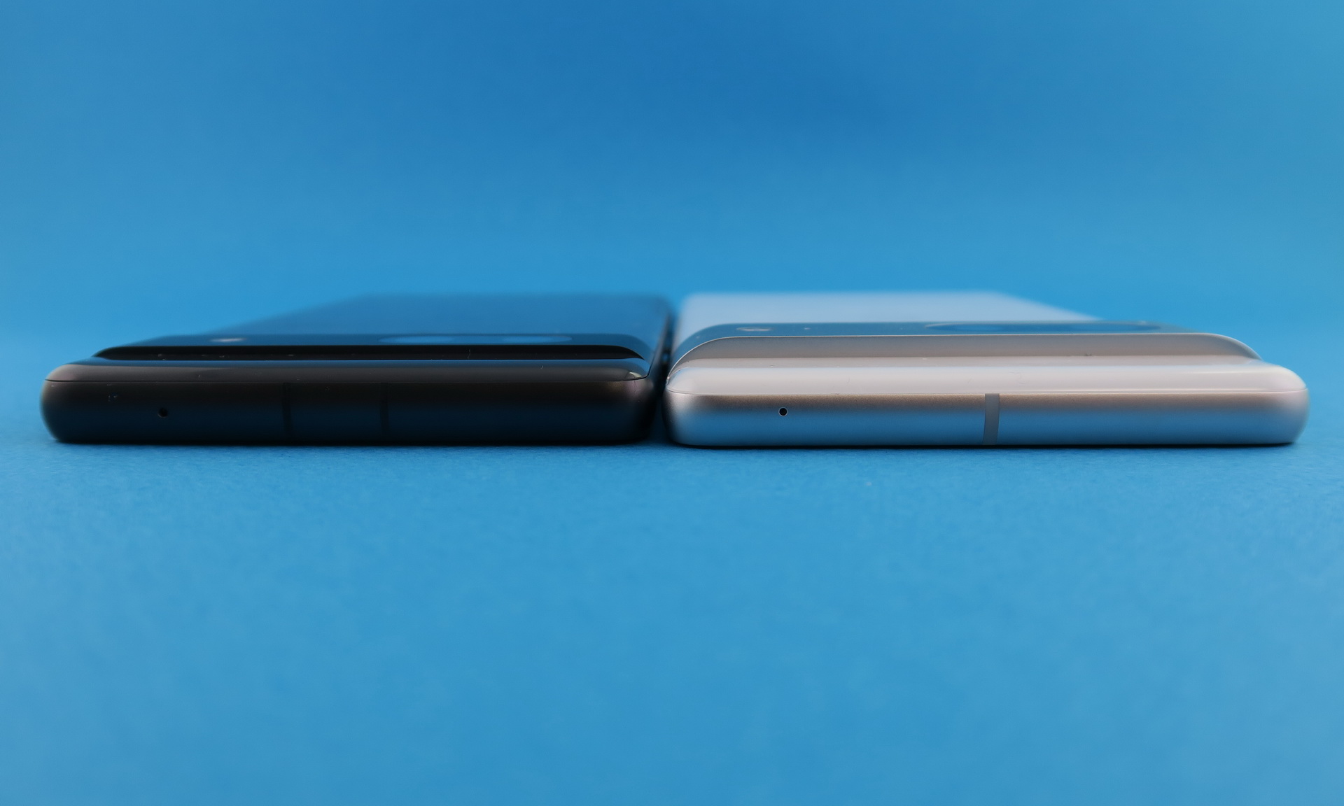 「Pixel 7a」（左）と「Pixel 7」（右）の上部。板状のボディ部分（カメラバー以外）の厚みは変わらないが、カメラバーは「Pixel 7a」の方が薄く仕上げられ、ボディ全体の厚みも抑えられている