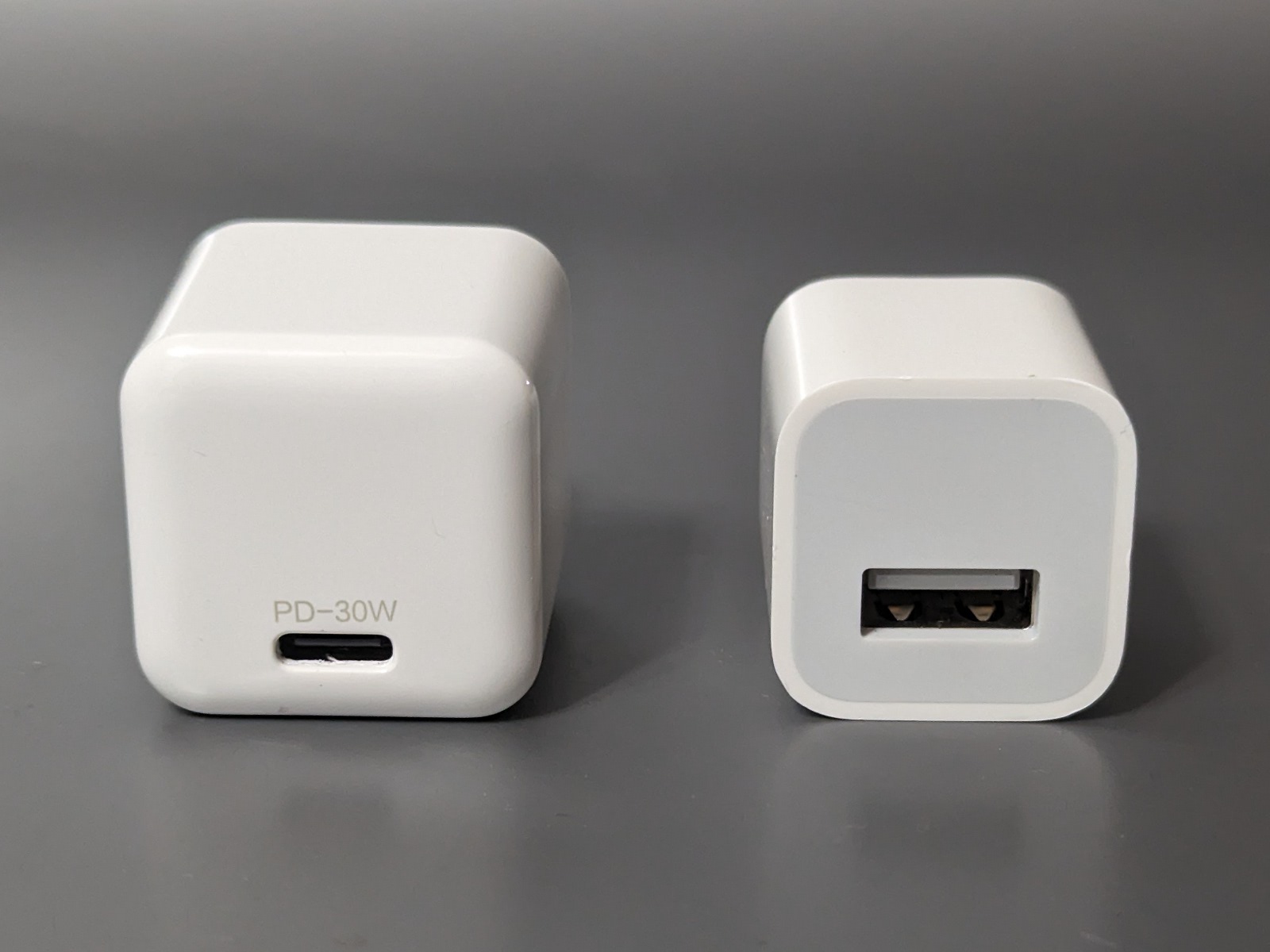 かつてiPhoneに付属していた1Aアダプター（右）よりひとまわり大きい程度