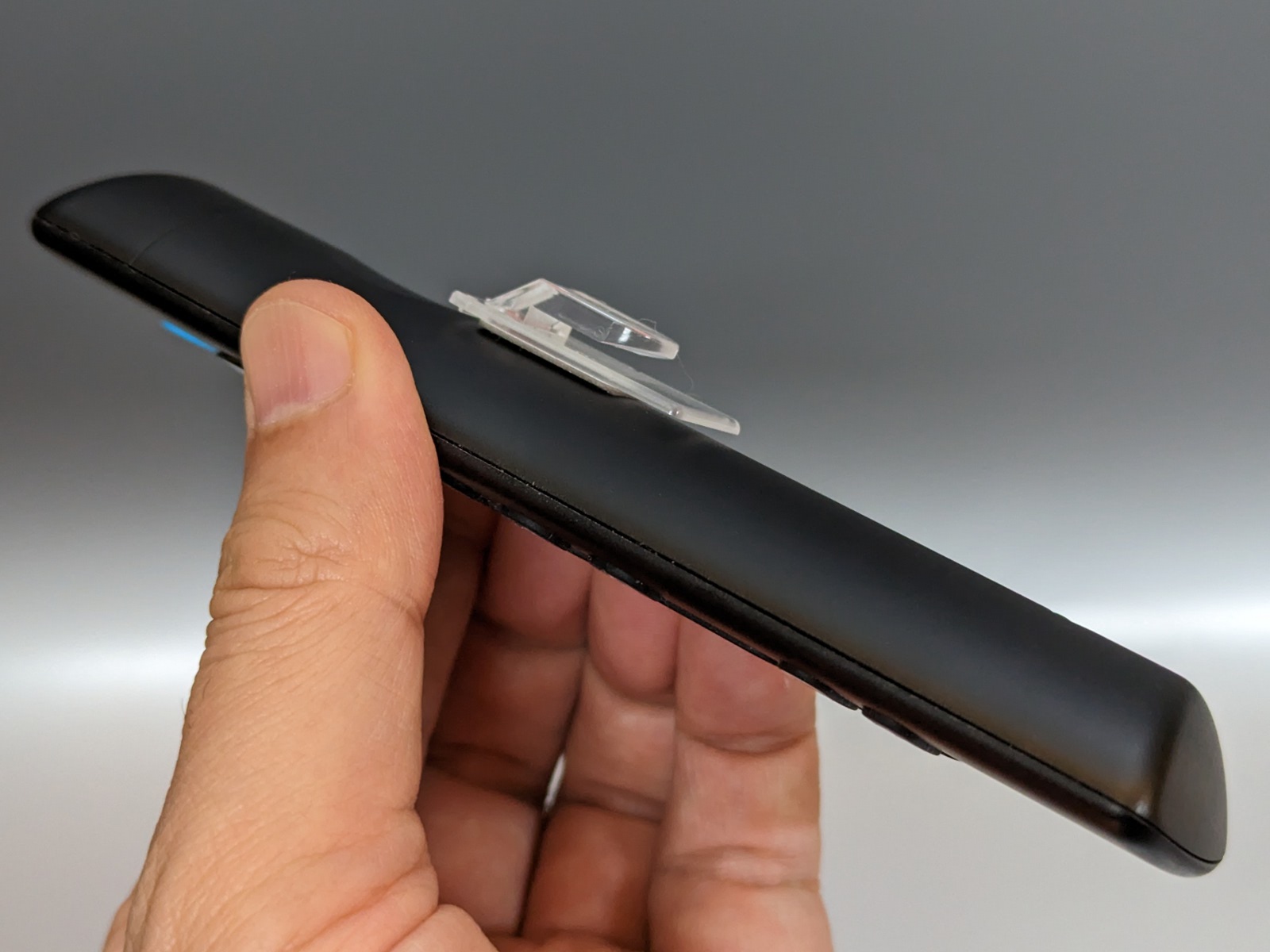 貼り付けた状態。背面が丸みを帯びたリモコンは端が浮くので注意