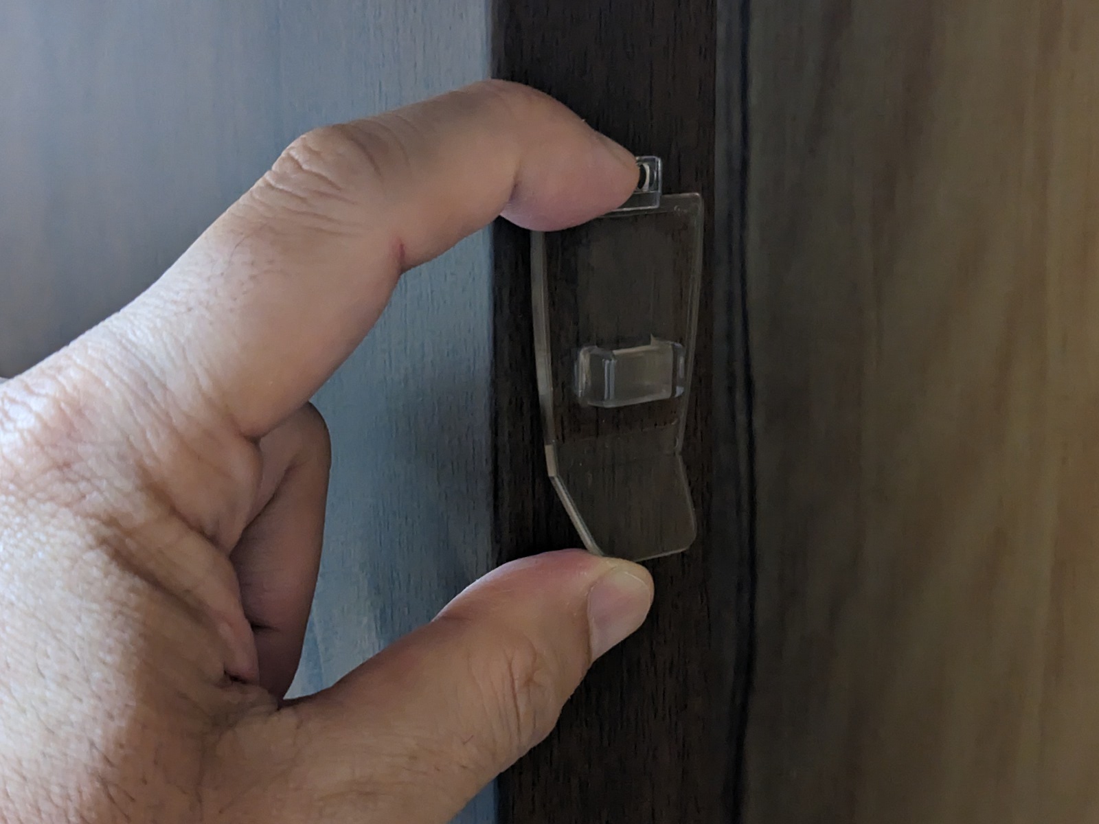 ベースは任意の位置に取り付ける。今回はテレビ台の側面に貼り付けた。合板などにステープラで固定するための穴もある