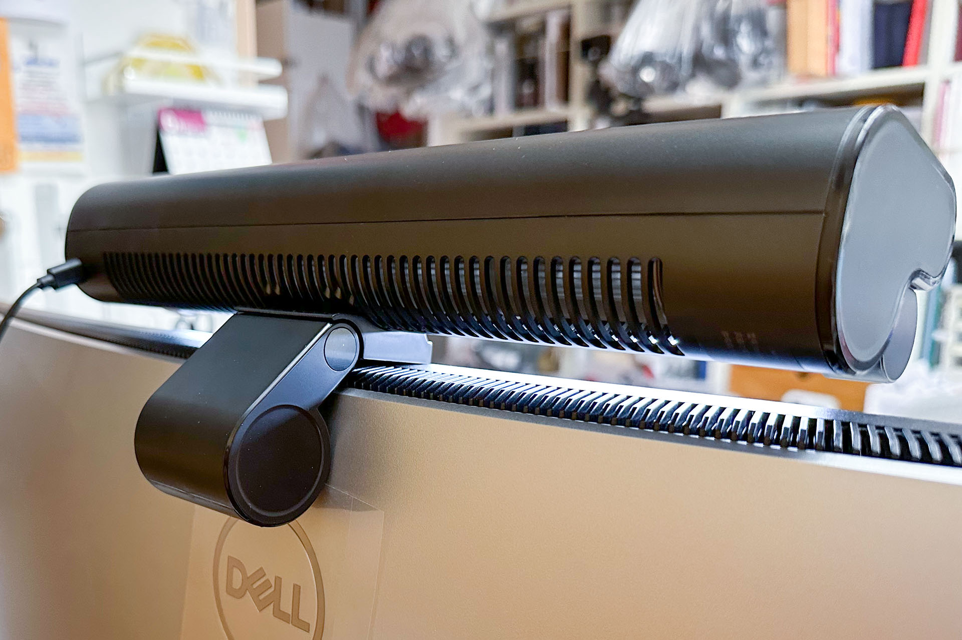 本体下のブラケットにより、ディスプレイ上部前後を挟むようにして置く。写真では少し浮いているが、ピタリと着けて置くことができる。