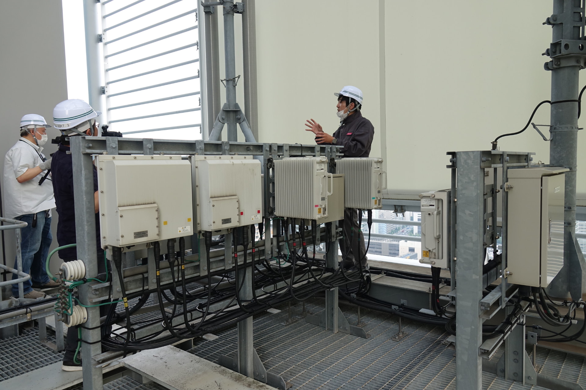 左＝地上約140mから地上の眺め。右＝地上からの眺め。ビルの出っ張った部分に大ゾーン基地局がある