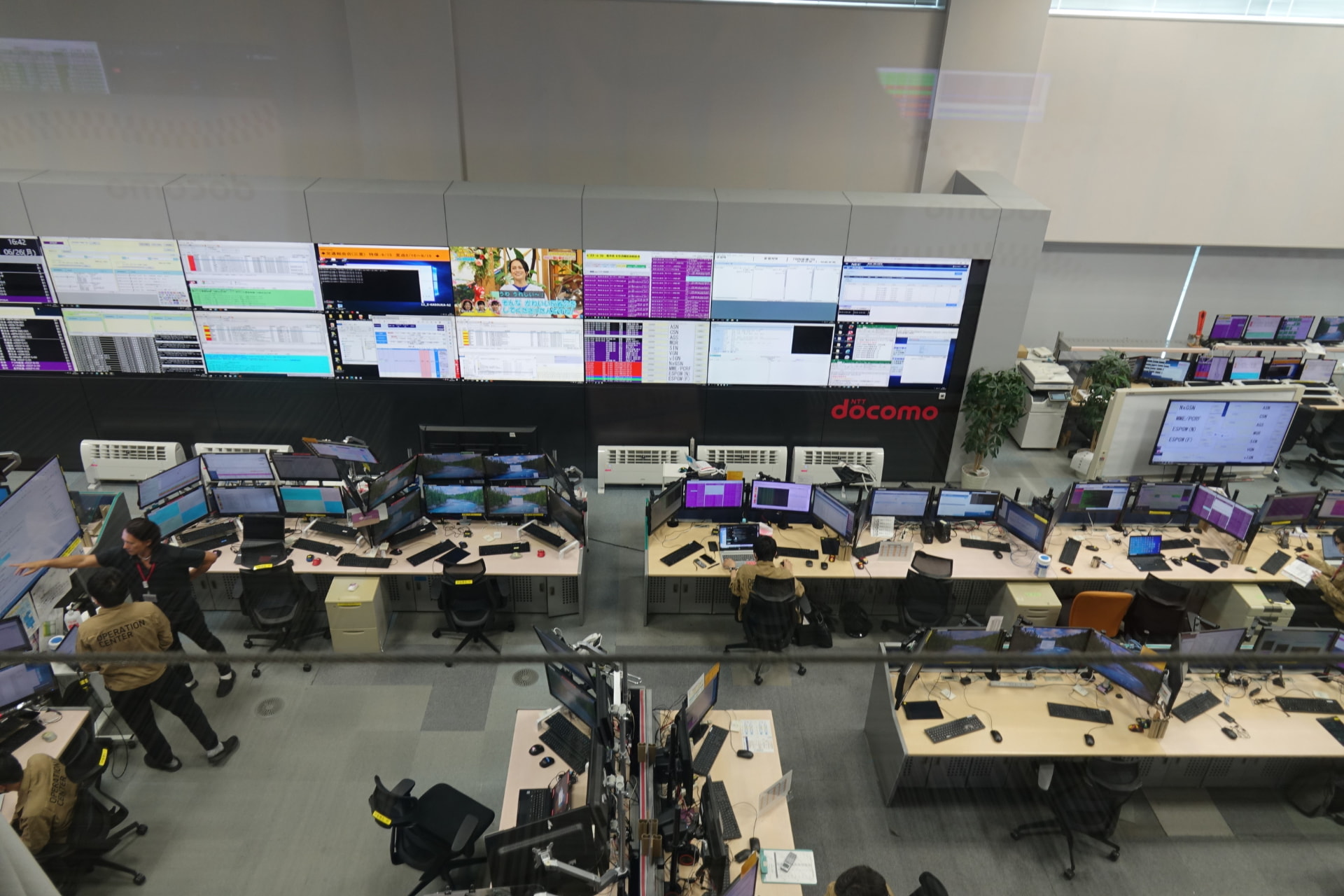 交換機を監視するオペレーター。パケット・音声通信のサービス状態などがわかる画面