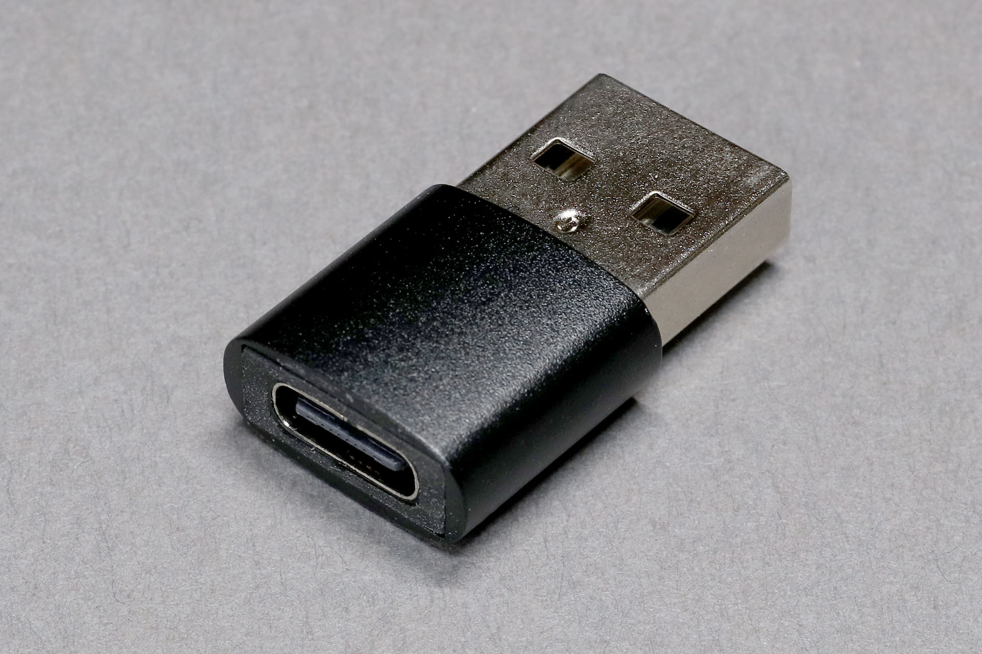 本製品の付属品、USB-AプラグとUSB-Cレセプタクル（ジャック）を持つUSB-C/USB-A変換コネクター。両端がUSB-Aプラグのケーブルを存在させてしまったりするため、使い方によってはこの変換コネクターにより大きな危険がもたさされるかもしれニャい！