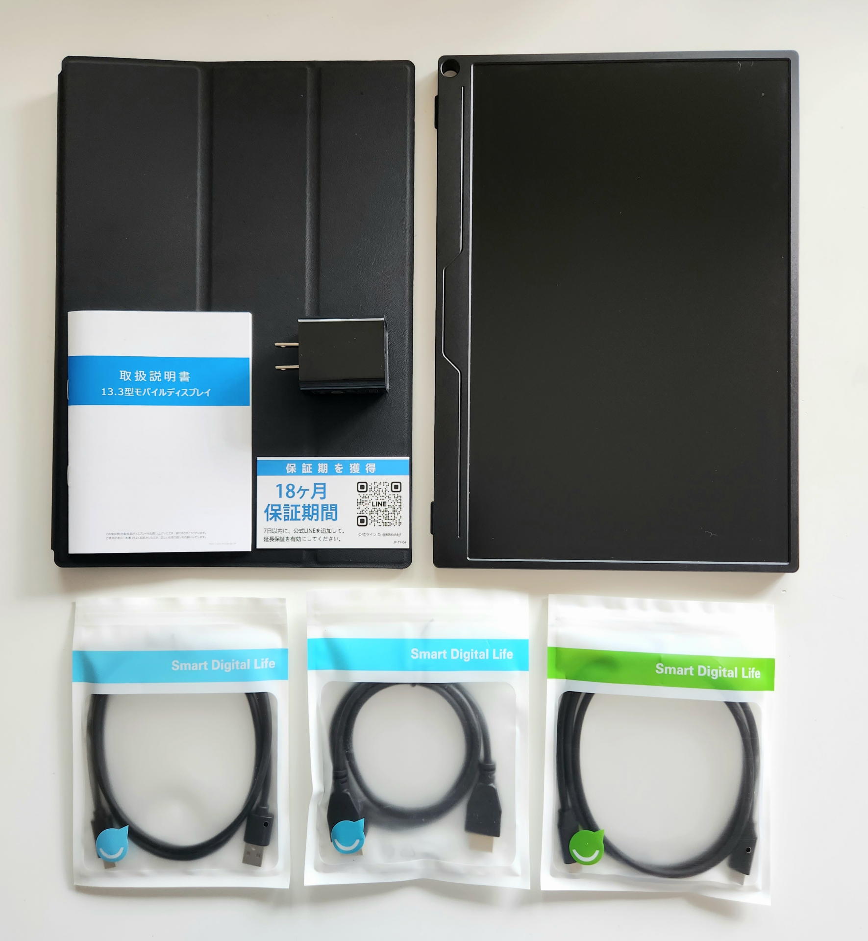 半額以下の1万5000円少々で手に入れた13.3インチモバイルディスプレイ。必要な接続ケーブル3本とスタンドカバーが同梱されている