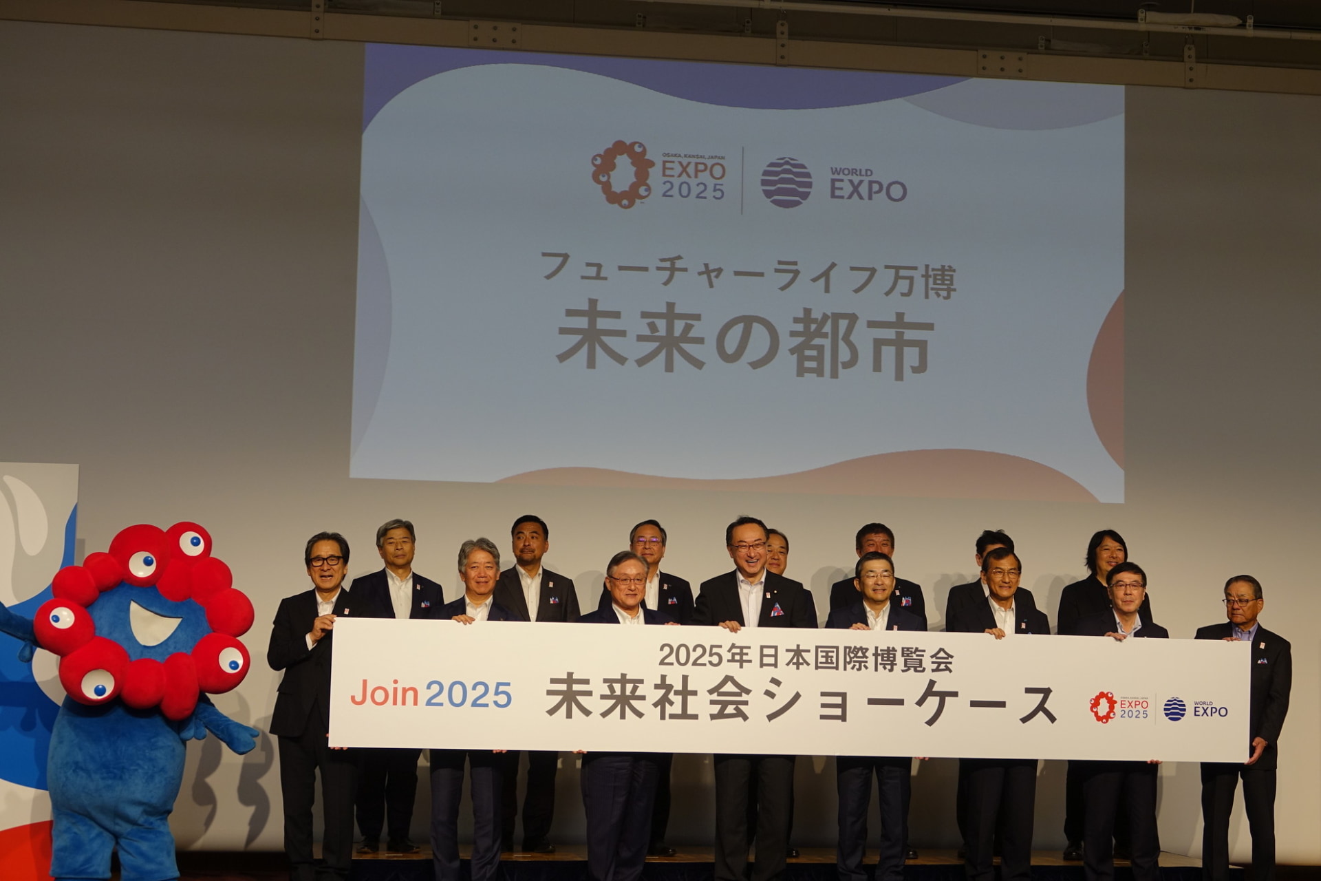 発表会の会場には、大阪・関西万博のキャラクター「ミャクミャク」も駆けつけた（左端）