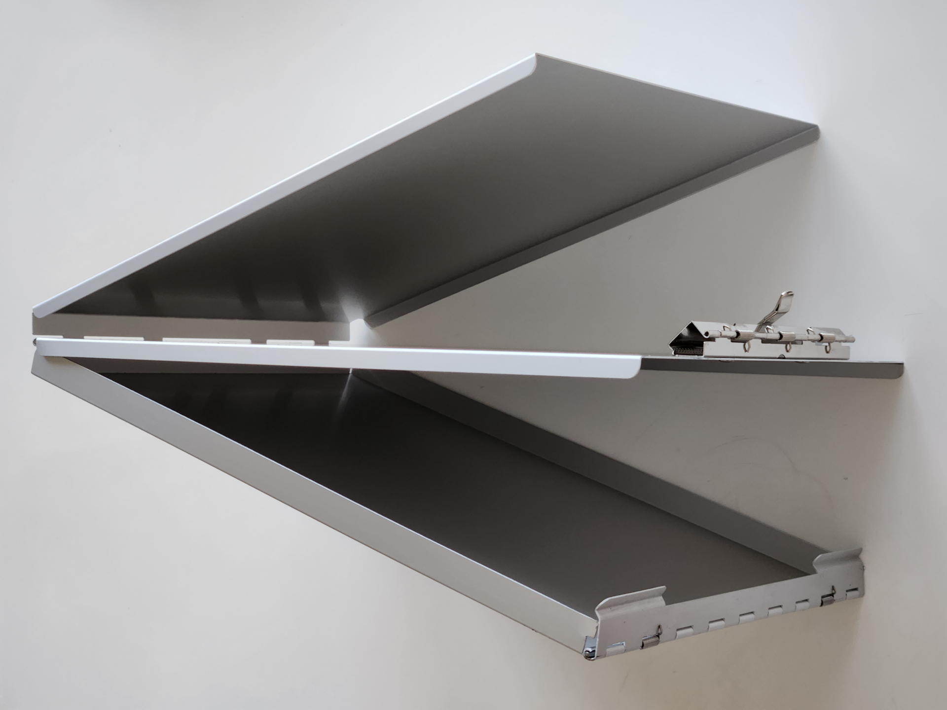 3枚のアルミ板を折り曲げてA4サイズ大のクリップボードと収納スペースを実現。収納スペースにはステーショナリー以外にも様々なモノを収納できる