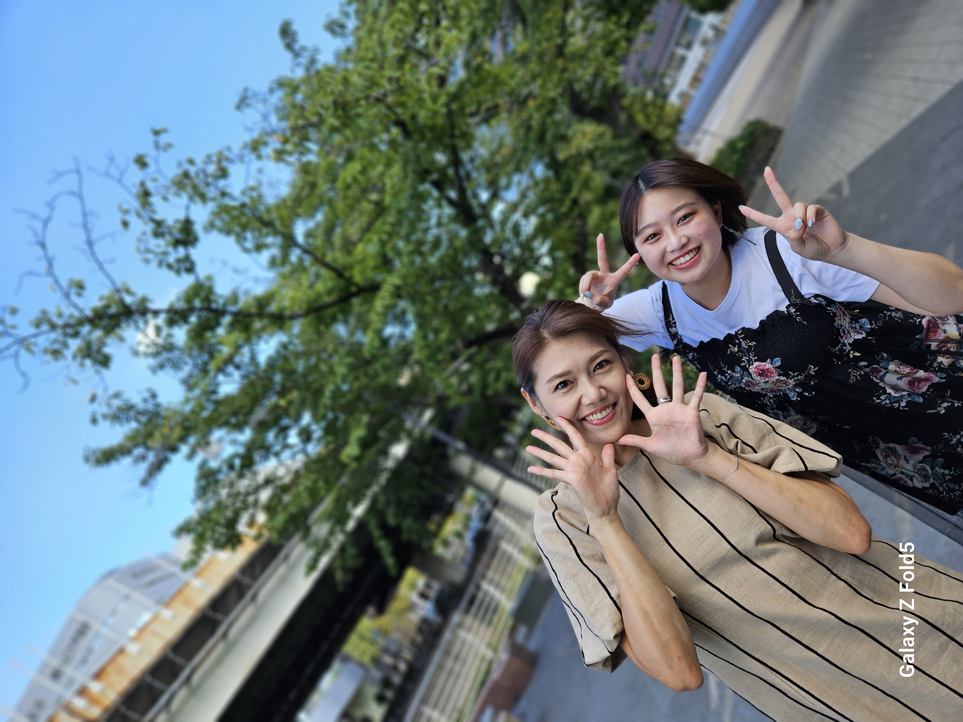 本体を開き、カバーディスプレイにプレビュー画面を表示して、メインカメラで撮影。被写体側からも写りがわかるので、ポーズも取りやすい。モデル：菅谷はつ乃（左）、葵木ひな（右）