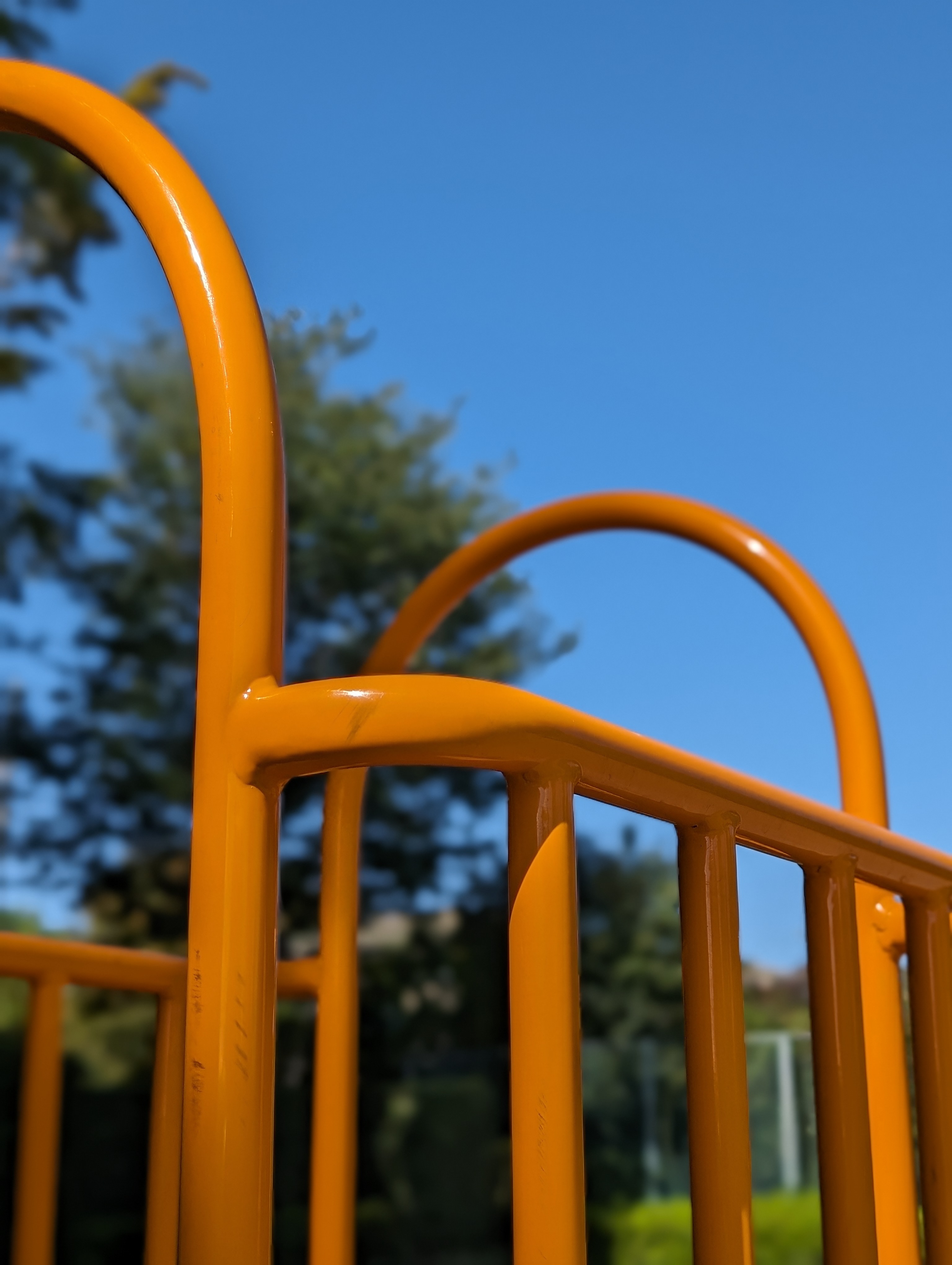 公園の遊具をポートレートモードで。何気ない光景も印象的なボケ感と発色で不思議な雰囲気のカットに。