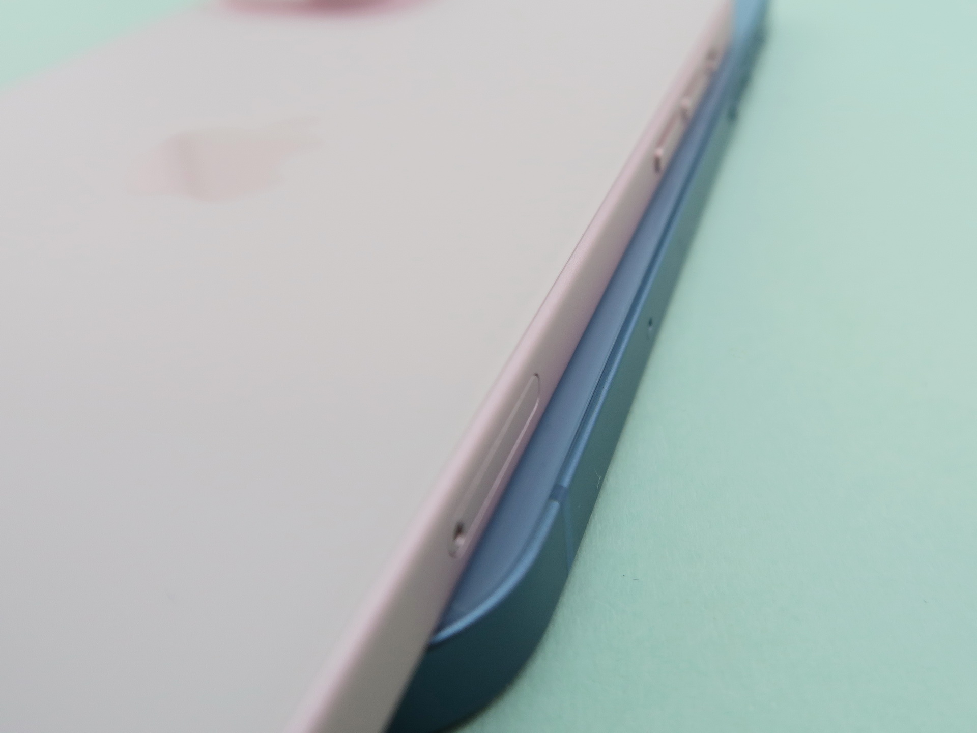 「iPhone 15」（左上）は「iPhone 14」（右下）に比べ、背面のエッジ部分の角が面取りされ、手当たりが改善されている