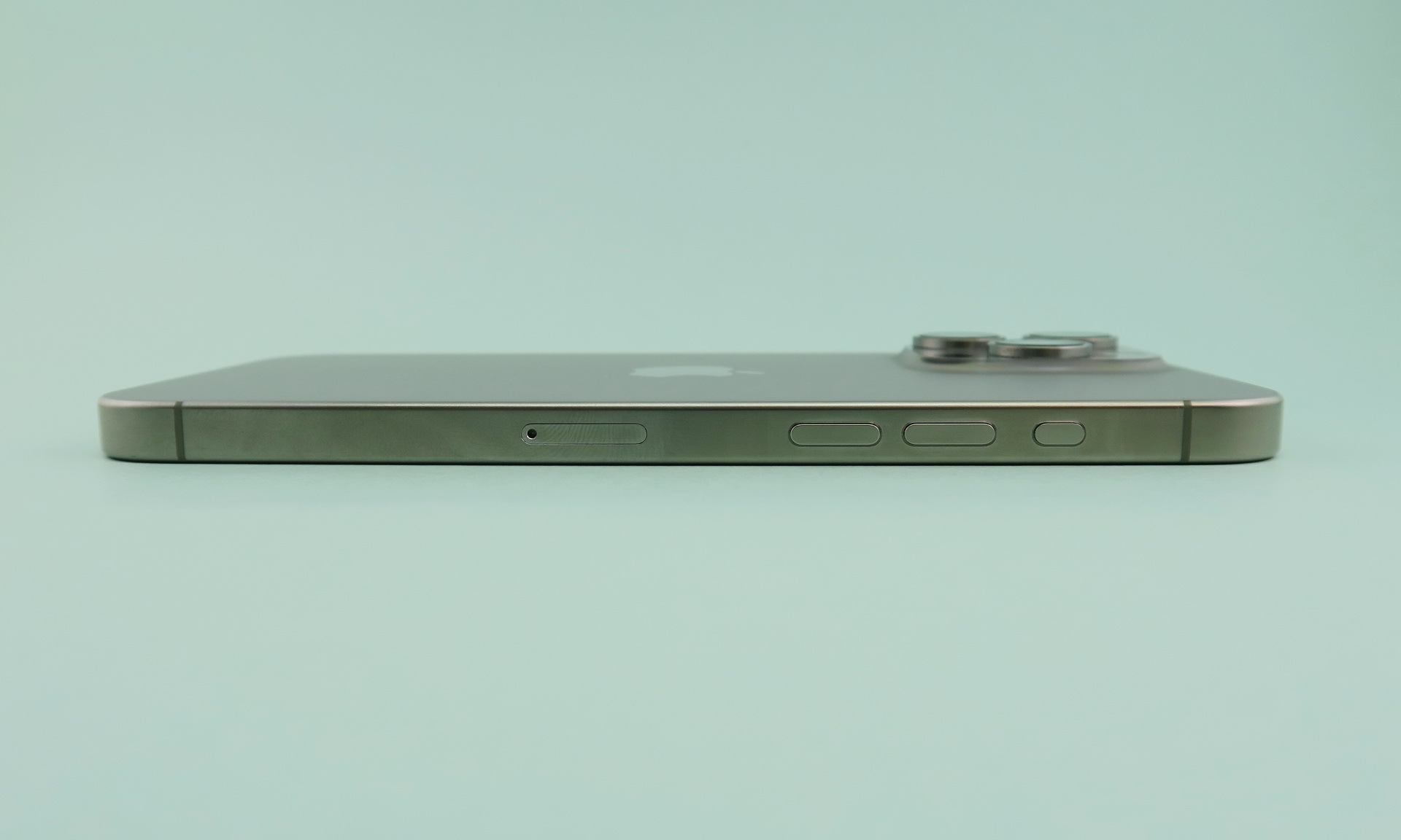 「iPhone 15 Pro Max」の左側面には、新たに採用されたアクションボタン、分割式の音量キー、ピンで取り出すタイプのSIMカードスロットが並ぶ。ナチュラルチタニウムは手の跡などが目立ちやすい