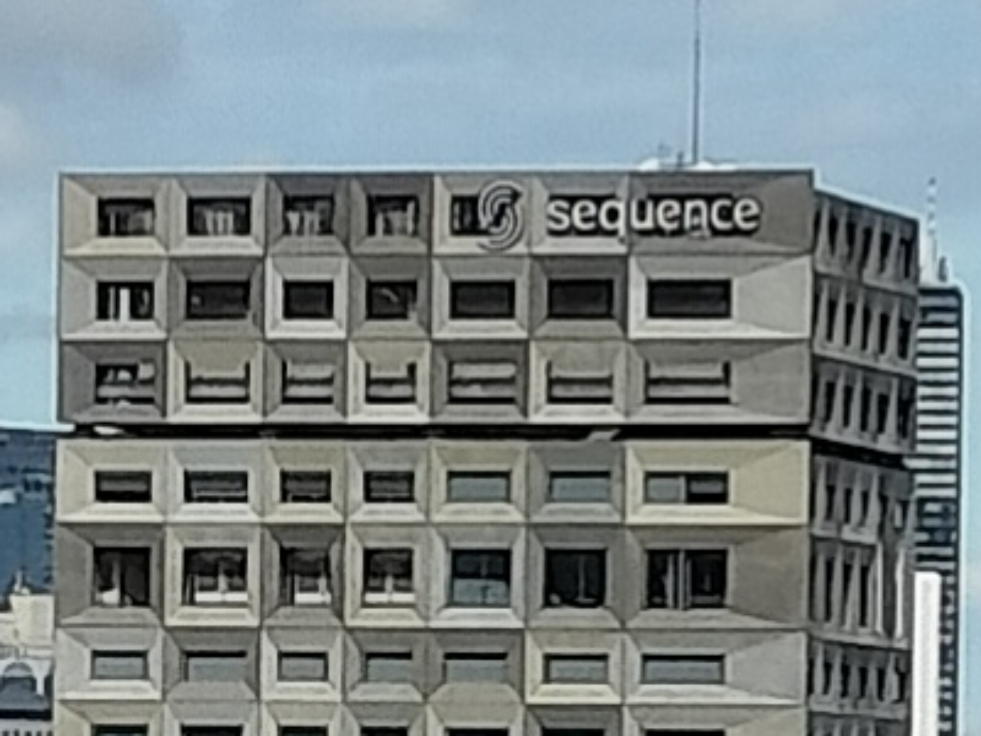 「2倍」の中央付近に写っているビルの部分を10倍に引き伸ばしたもの。光学ズームだからか、文字はしっかり読める