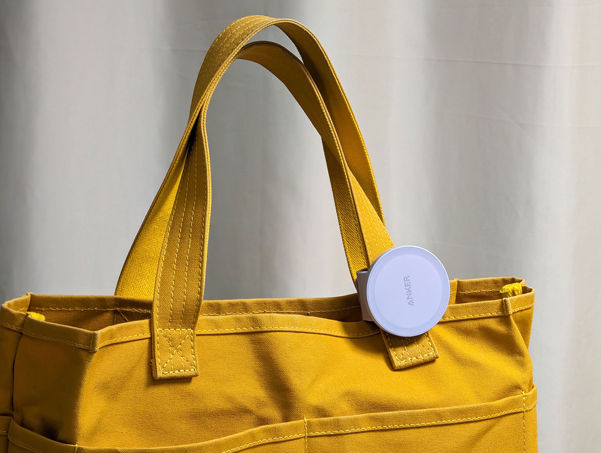 バッグのハンドルにAnker 620 MagGo Phone Gripを装着。Anker 620 MagGo Phone Gripは全体的に磁石の塊って感じなので、磁気カードや磁気に強くないアイテムと一緒に持ち歩くのが憚られるが、それらアイテムとある程度離した位置にセットしておけば気軽に持ち歩ける。