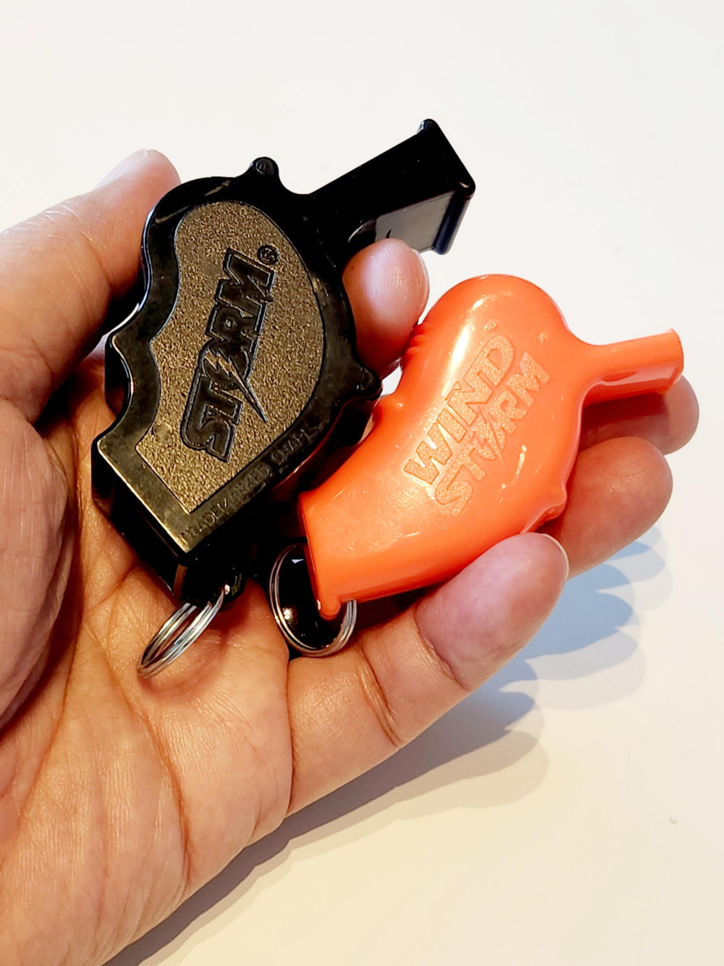 大きさも出っ張り具合もだいぶん違う2本のStorm笛。黒い方は22g（鉛筆3本分ほどの重さがある）