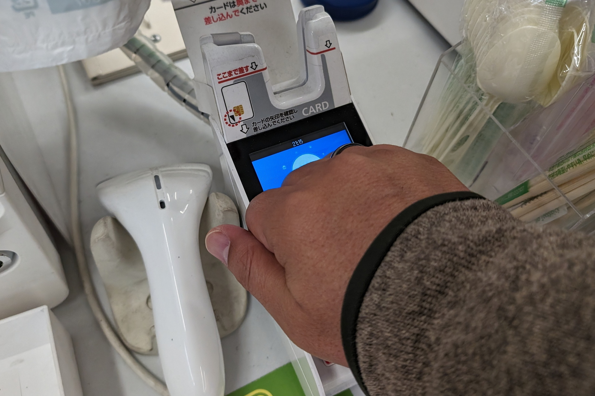 リングを装着した手でグーを作り、指先側を決済端末に近づけることで決済を行う