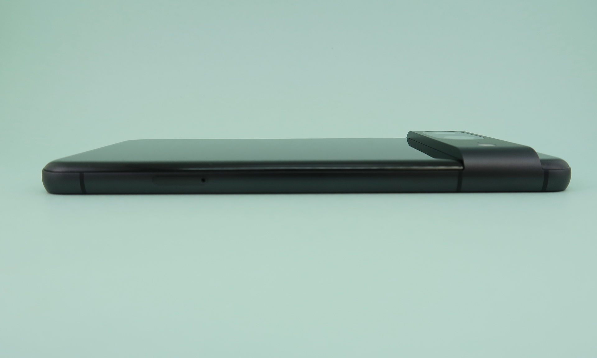 左側面はやや下部寄りの位置にSIMカードスロットを備える。本体が短くなったこともあり、ややカメラバーの大きさが目立つ