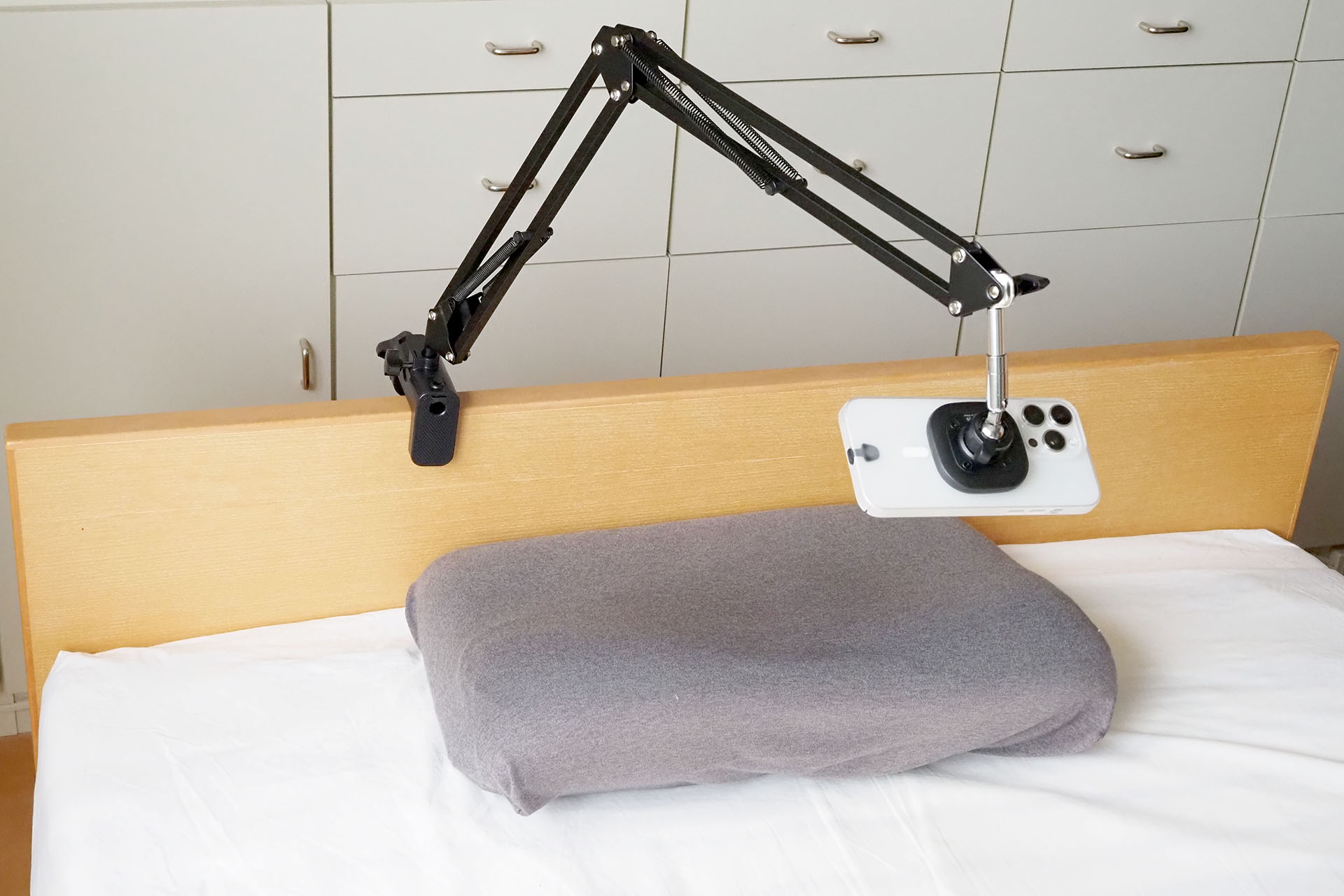 実際にベッドのヘッドボードに固定した様子。寝た状態でスマートフォンを使える。
