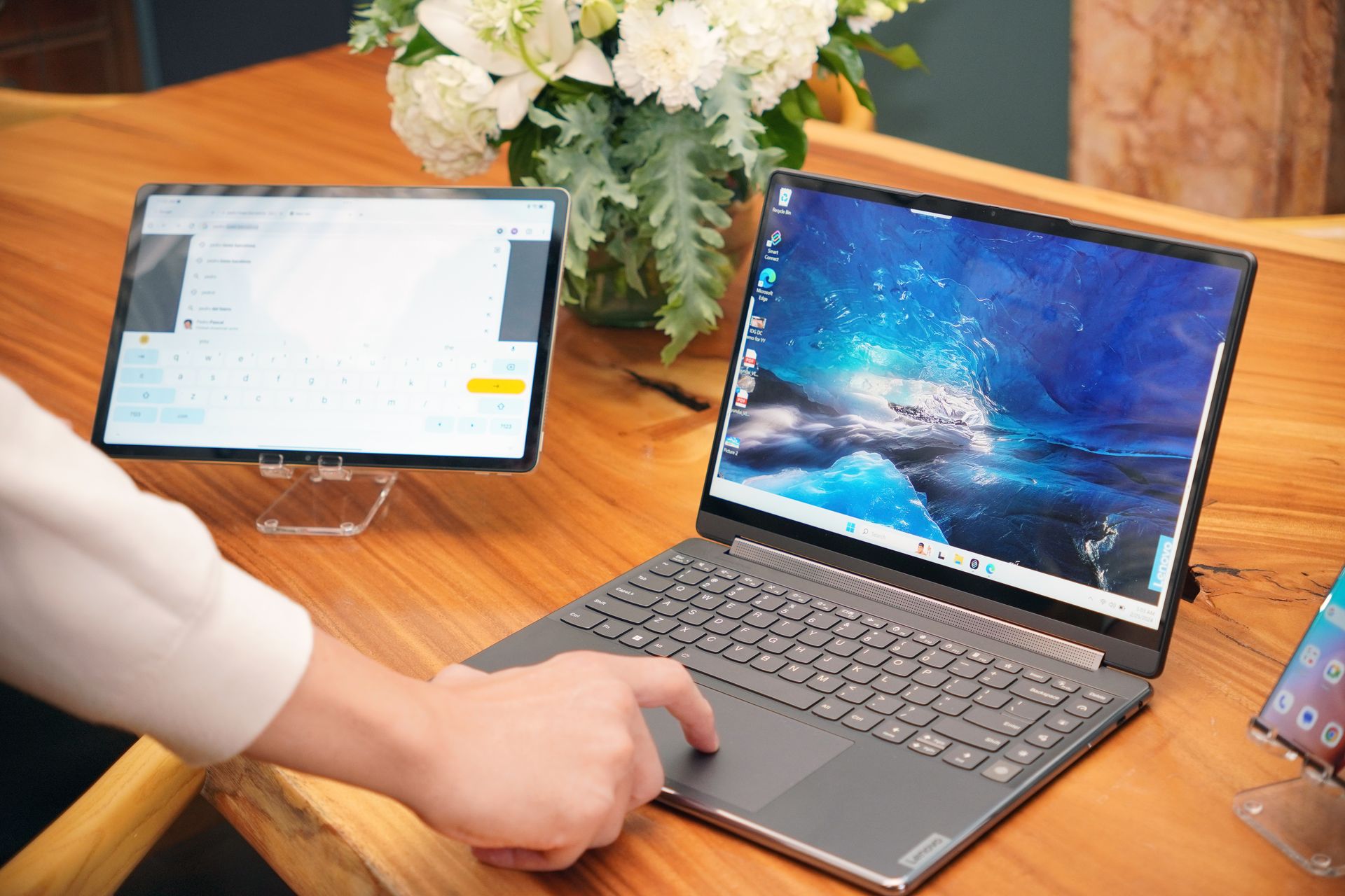 パソコンのキーボードやタッチパッドで、タブレットを操作しているシーン