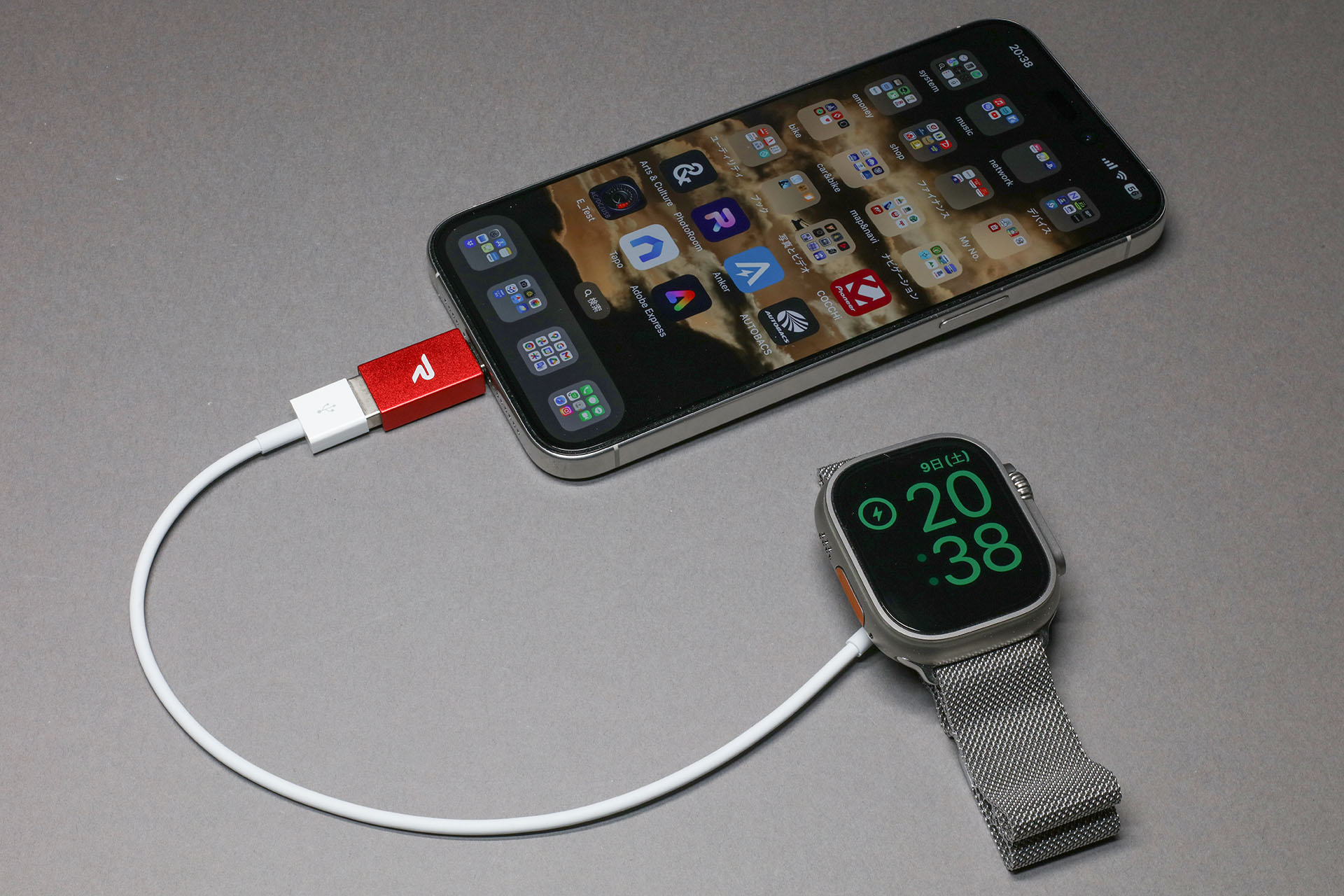 iPhone 15 Pro MaxにUSB-C/USB-A変換コネクターを経由してApple Watch磁気充電ケーブルをつなぐ。ここにApple Watchを置くと……。