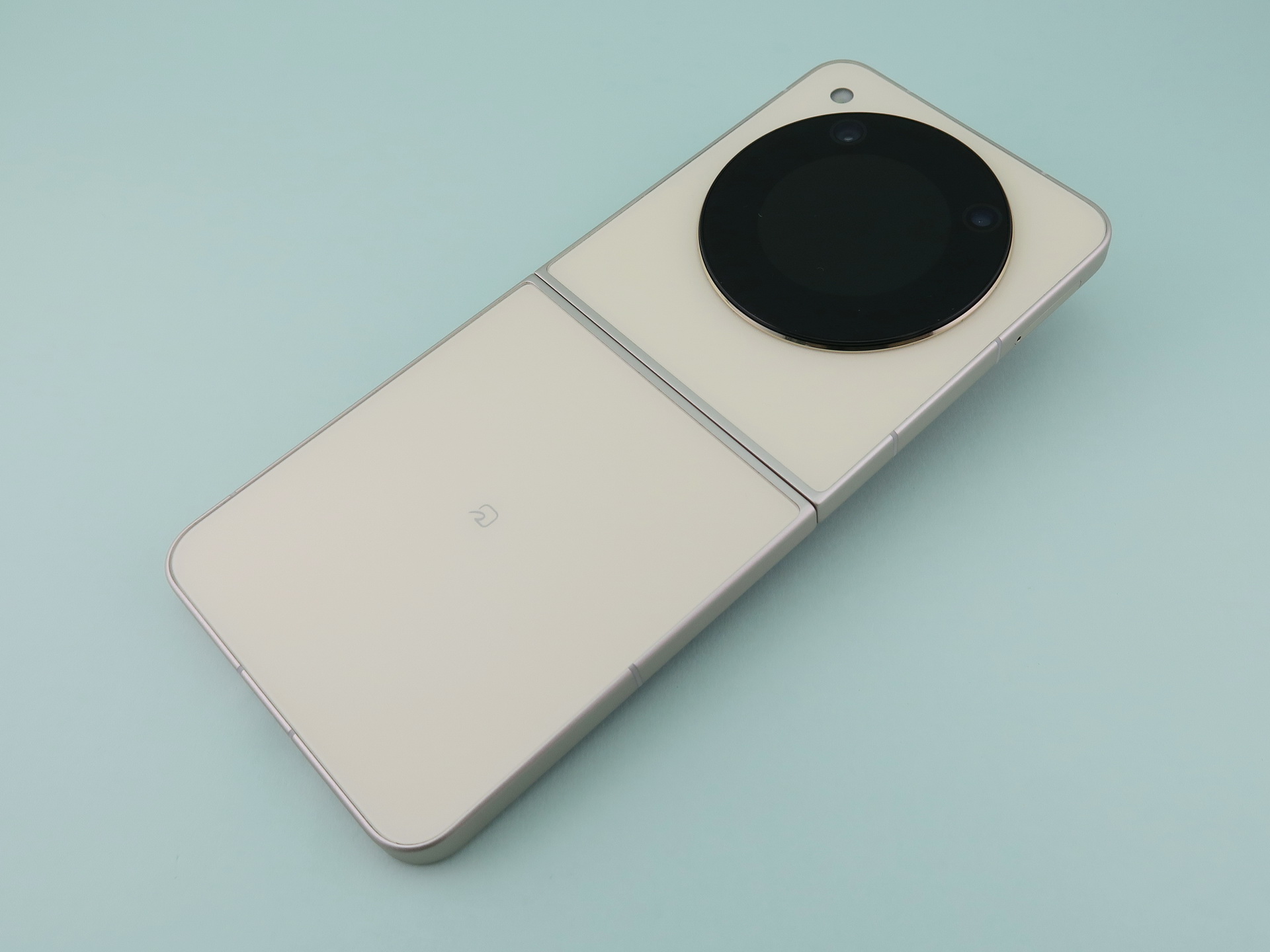 端末を開いた状態の背面。背面側も上下の筐体がぴったり合わさり、ほぼフラットな状態になる。背面側のガラスには細かい模様の凹凸が付けられていて、指紋などがつきにくい