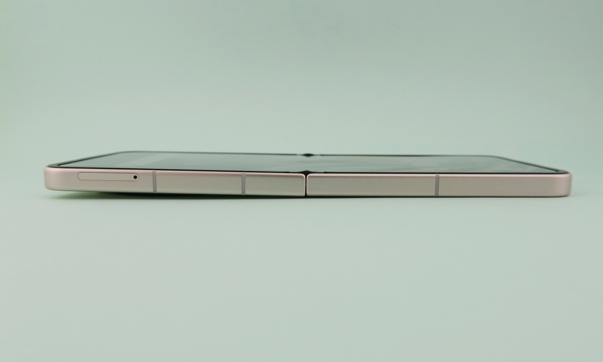 端末を開いた状態での左側面。斜めになっているが、これは上筐体（左側）背面のカメラ部が出っ張っているため。ディスプレイはほぼフラットに近い