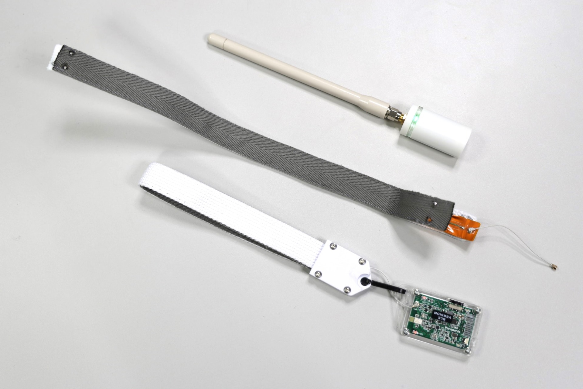 受電できるデバイス、中央のものはストラップ型受電装置を開いたもの