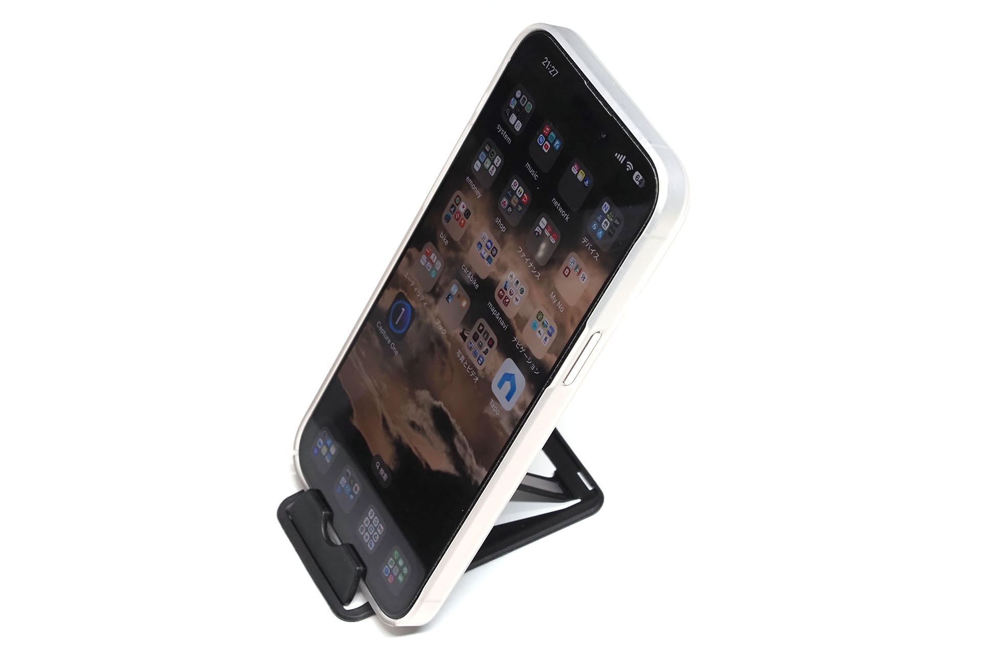 iPhone 15 Pro Maxを置いた様子。端末を置くときは下側のストッパーを展開する。この状態で端末タップするとスタンドごと後退するくらいよく滑る。