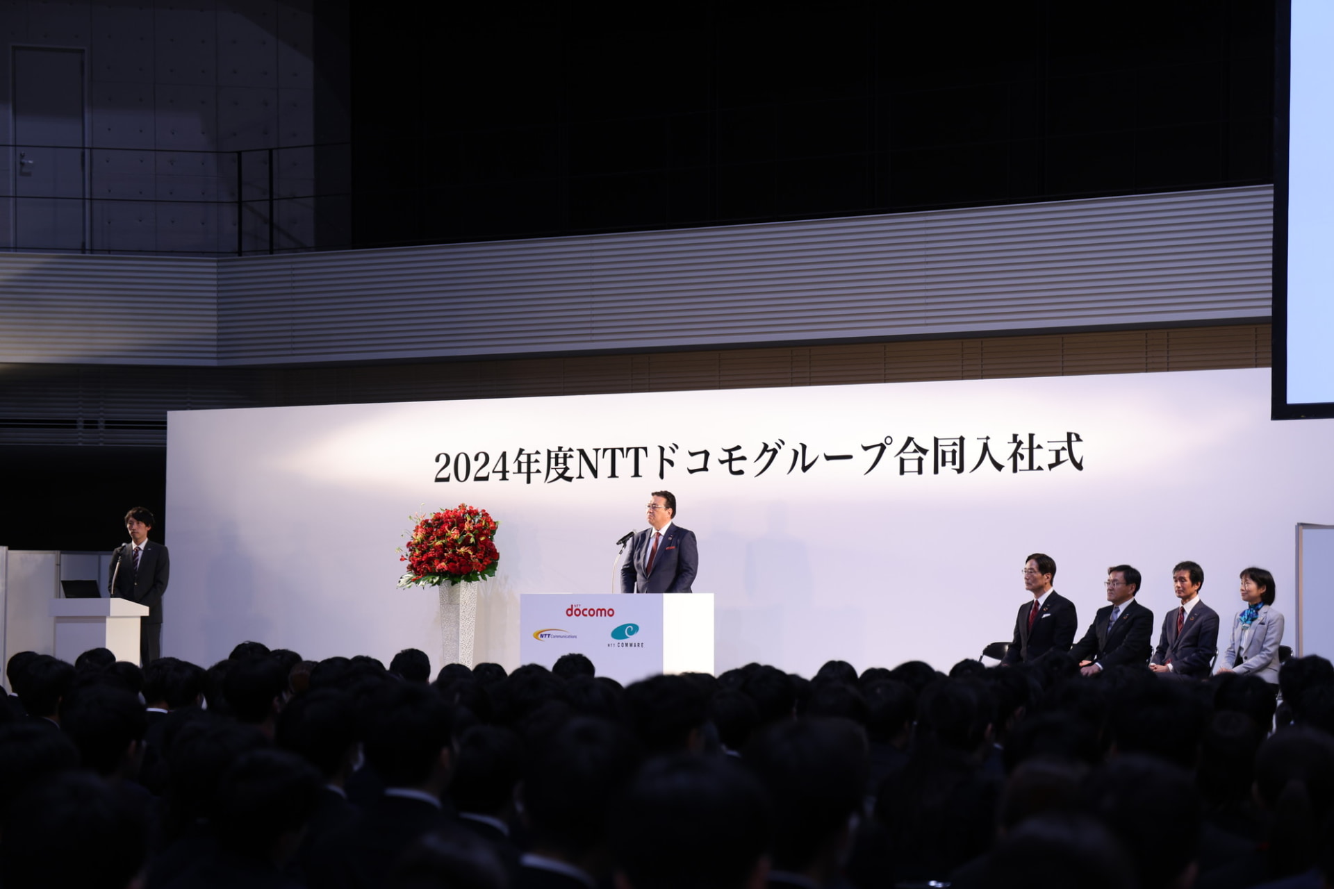 3社合計約1200人の新入社員の前で挨拶するドコモ井伊社長