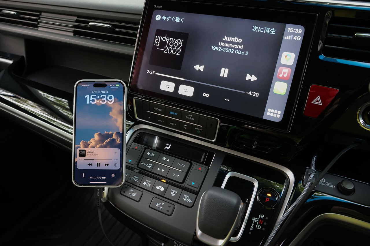 ケーブルを引き出してiPhoneに挿してCarPlayを使用中の図。iPhoneはMagSafe対応の車載ホルダーにセットしている。