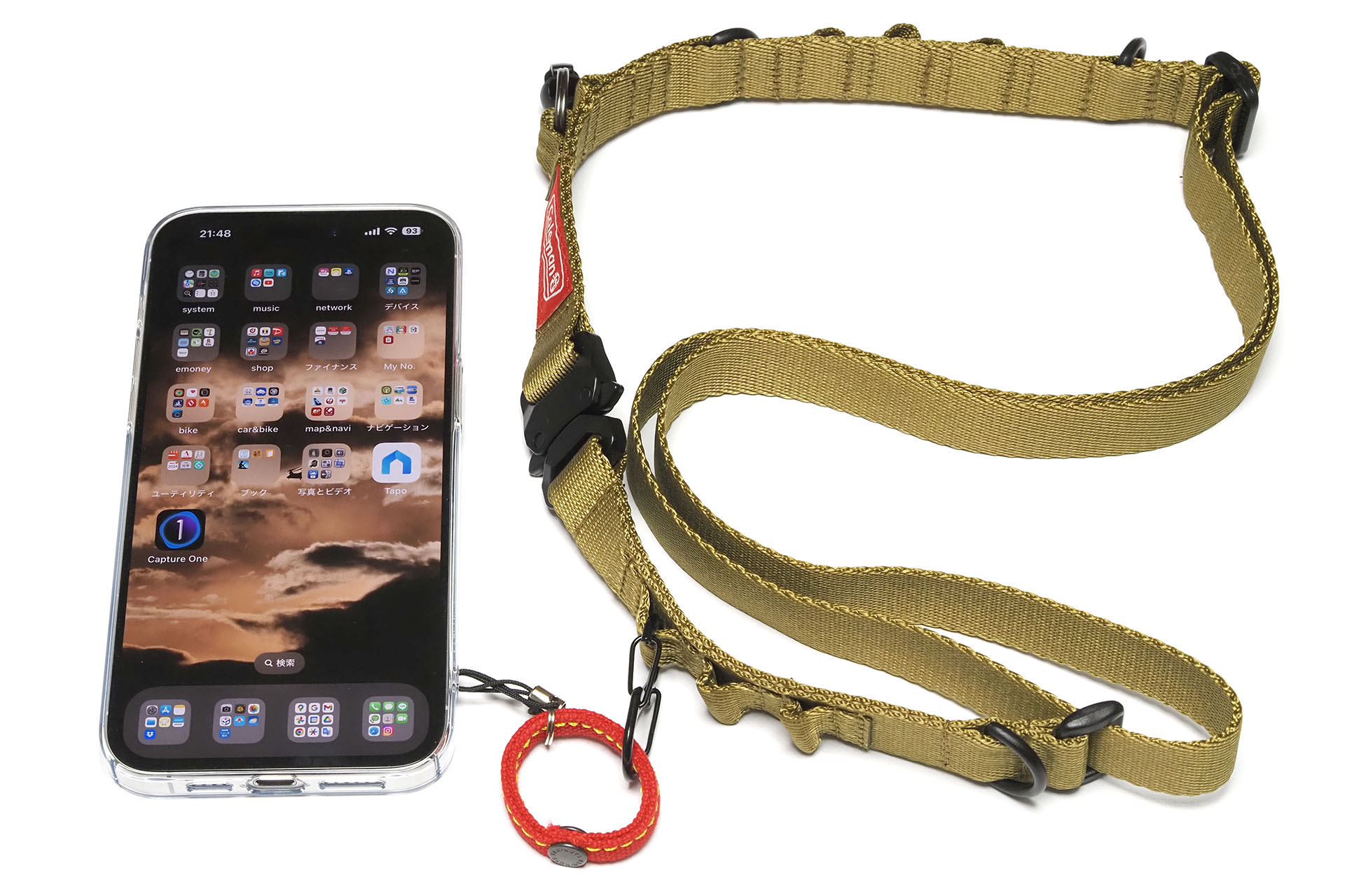 細身のボディストラップ的なものに、カラビナ的なものを追加し、そこにリングつきスマートフォンを接続。スマートフォンを斜め掛けできるようになる。ショルダーストラップはエツミ<a href="https://www.etsumi.co.jp/products/coleman/detail/10196" class="strong bn" target="_blank">「コールマン ハンギングストラップ」</a>だ。Amazonでは<a href="https://www.amazon.co.jp/dp/B09PDGKS1S" class="strong bn" target="_blank">2910円</a>。