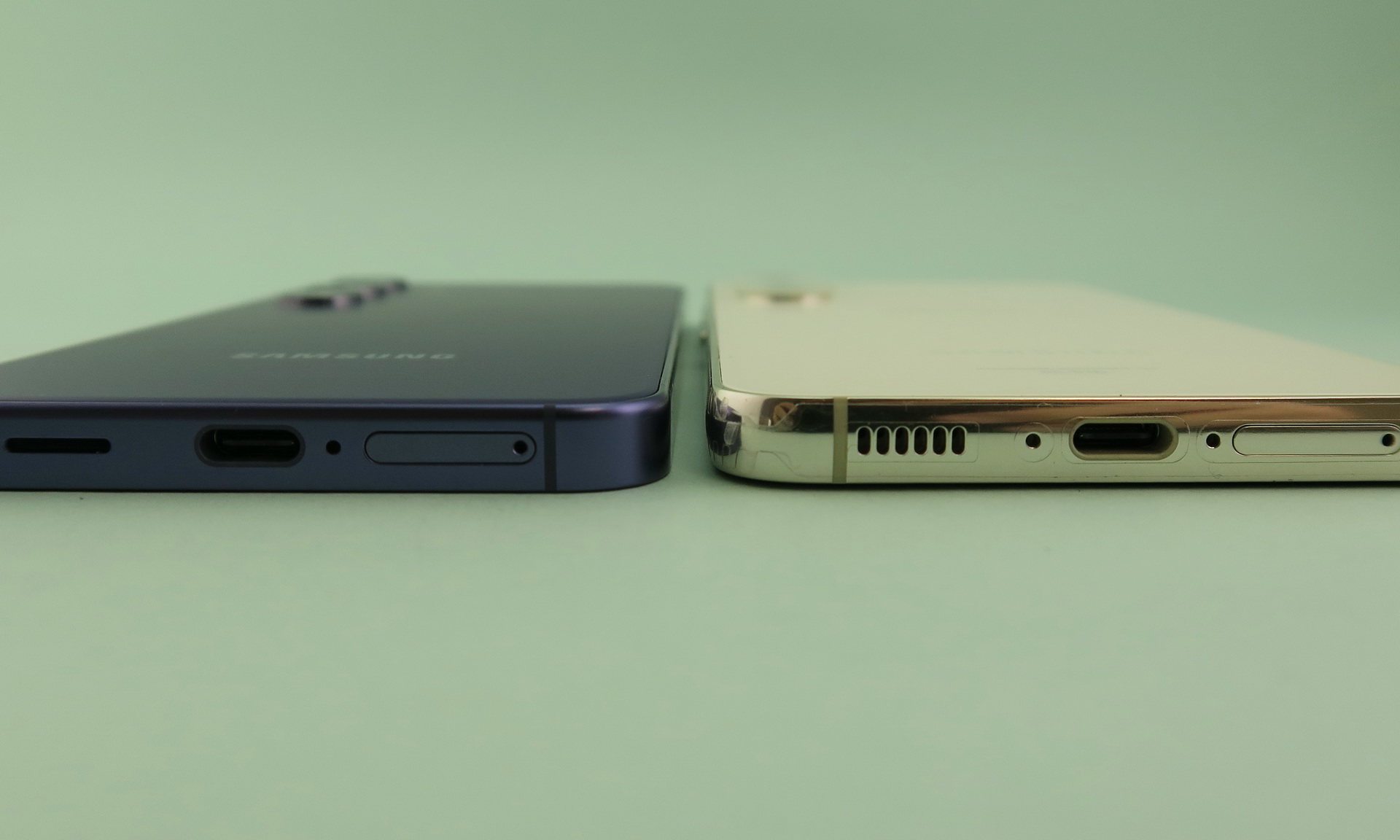 「Galaxy S24」（左）と「Galaxy S23」（右側）を下部側から見たところ。側面の仕上げが変更されたことがわかるs