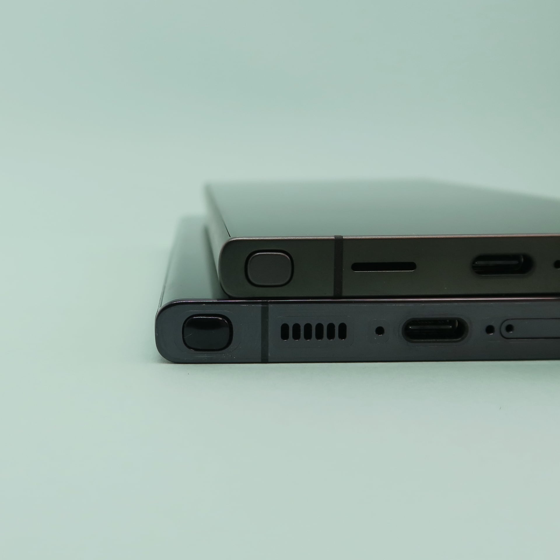 「Galaxy S24 Ultra」（上）と「Galaxy S23 Ultra」（下）を重ねて、側面の形状を比較。側面へ回り込む部分の湾曲する形状が異なる。下部の放熱用の穴のデザインも変更された