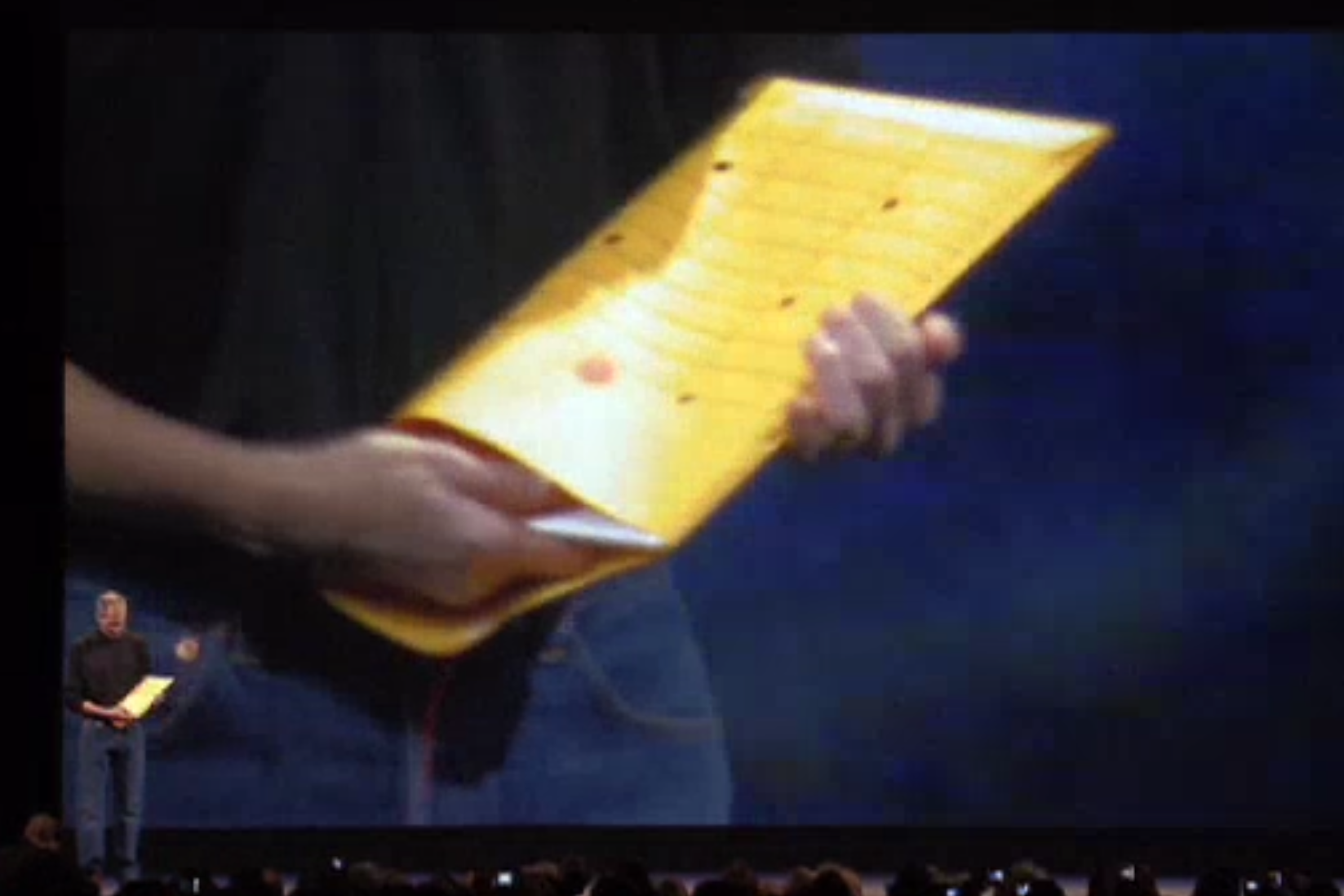 2008年のMacworld Expo基調講演でビジネス封筒からMacBook Airを取り出すジョブズさん。マシンの薄さを強調するイキな演出であった。※画像は公式配信より引用。