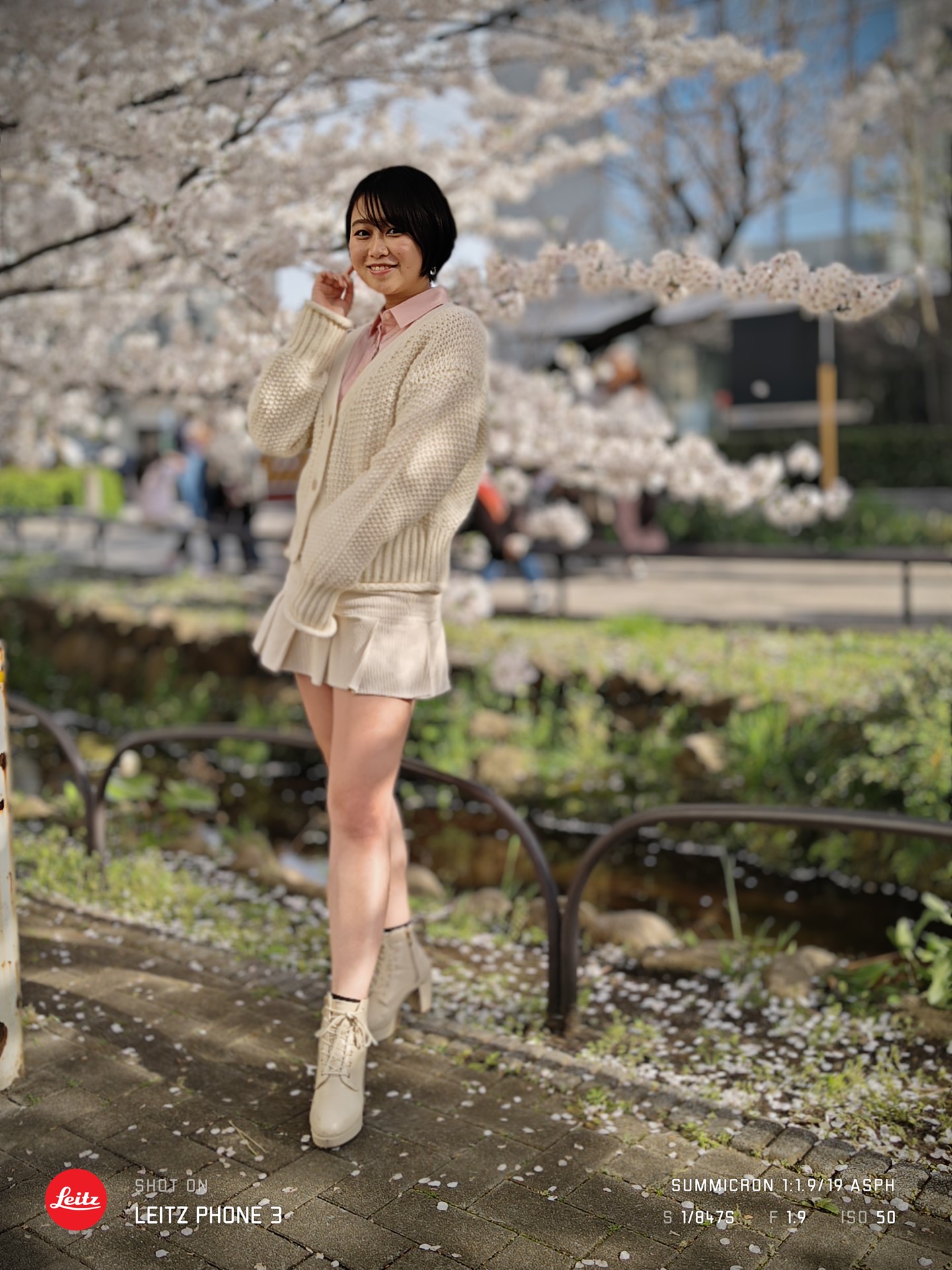 桜並木を背景に撮影。人物が際立って撮影できているが、少し色合いが他の写真と違う印象