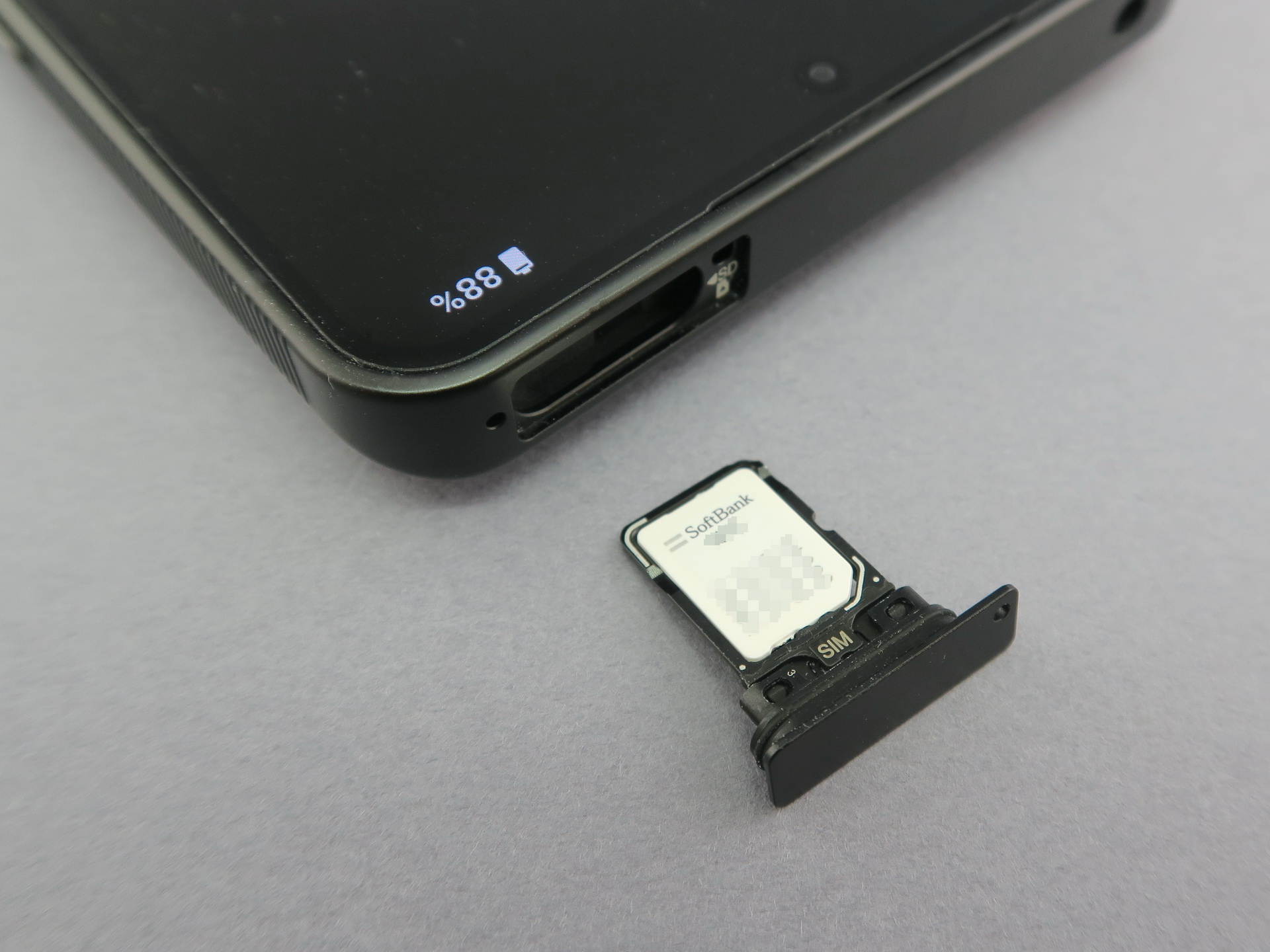 本体上部にはピンで取り出すタイプのSIMカードトレイを備える