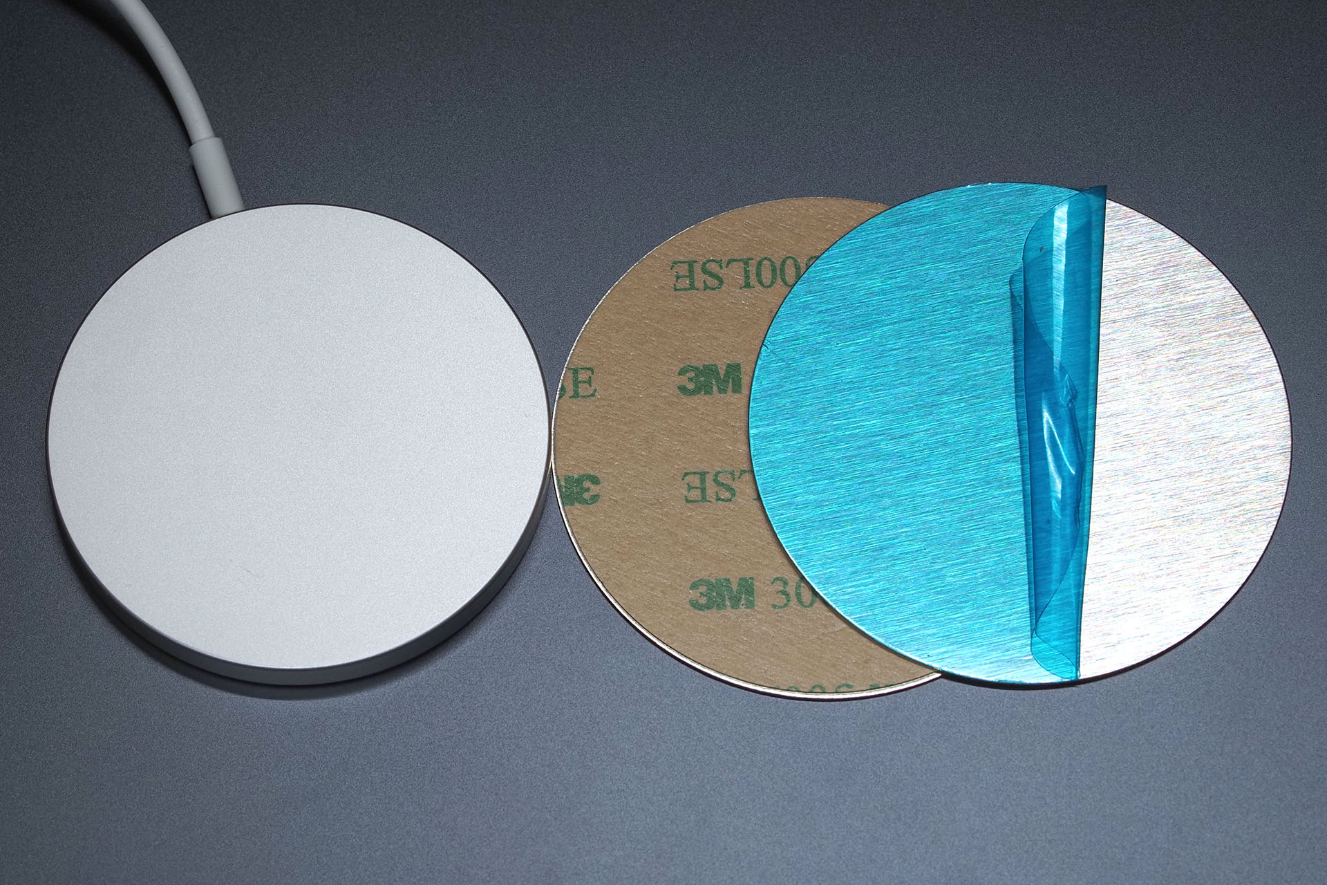 こんなプレートを使い、Apple純正MagSafe充電器をMagSafe対応スマートフォンスタンドに吸着できるようにした。直径60mmの丸いステンレススチールプレートで「マグネット吸着用」としてAmazonで売られていた。