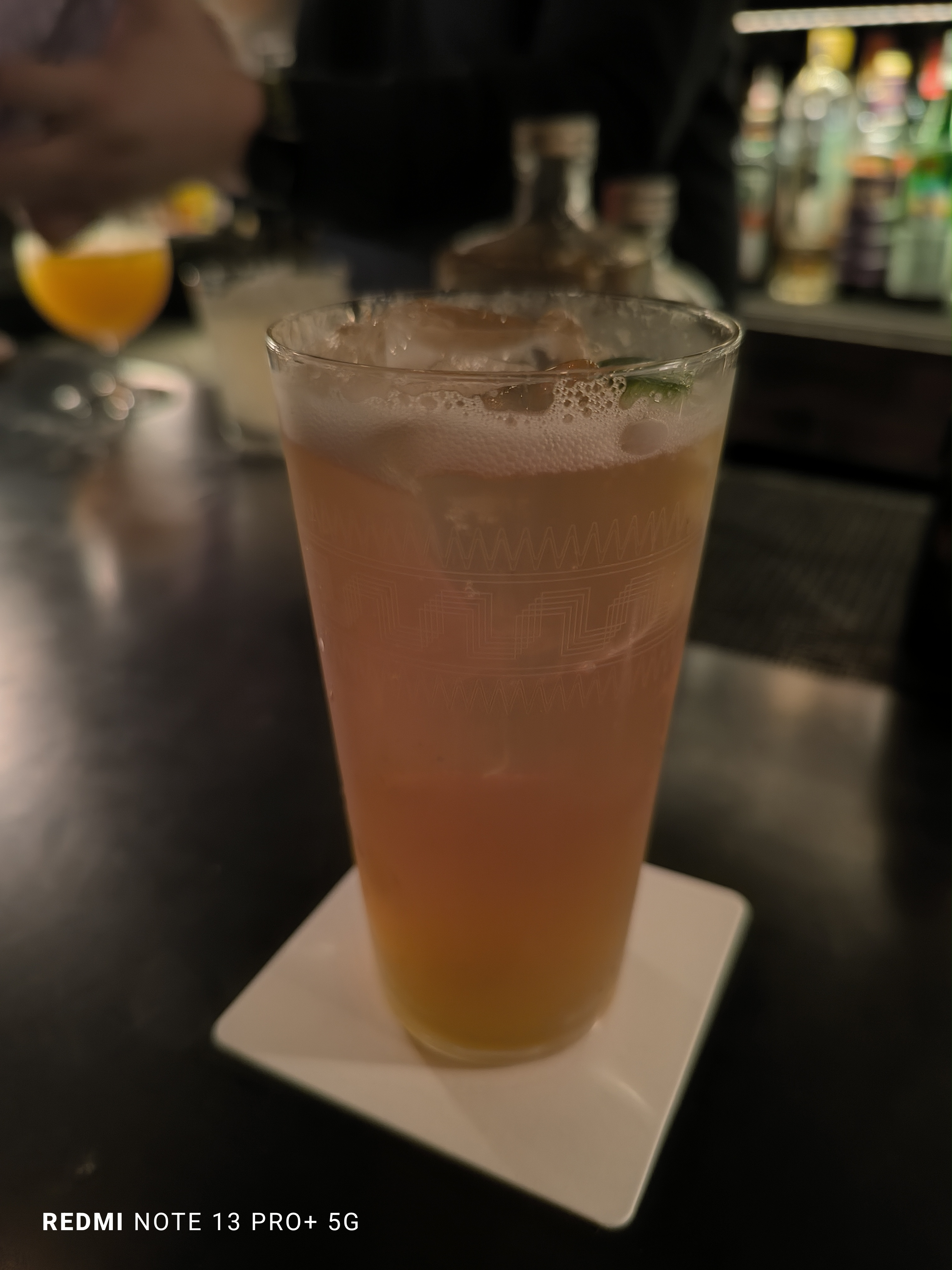 薄暗いバーで撮影。背景をぼかしながら、明るく撮影できている。グラスに施された細かい柄も再現されている