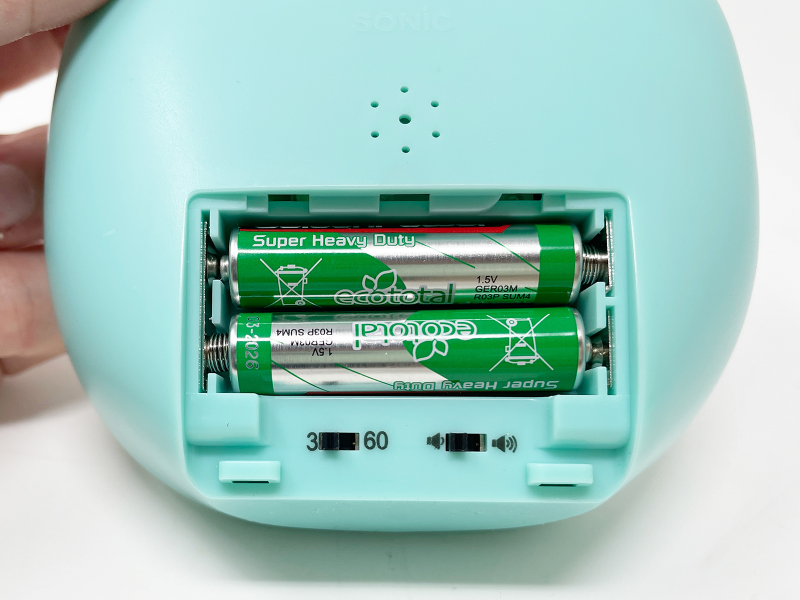 単4電池を2本使用。電池カバー下には、アラームの回数や音量を設定するスイッチがあります。