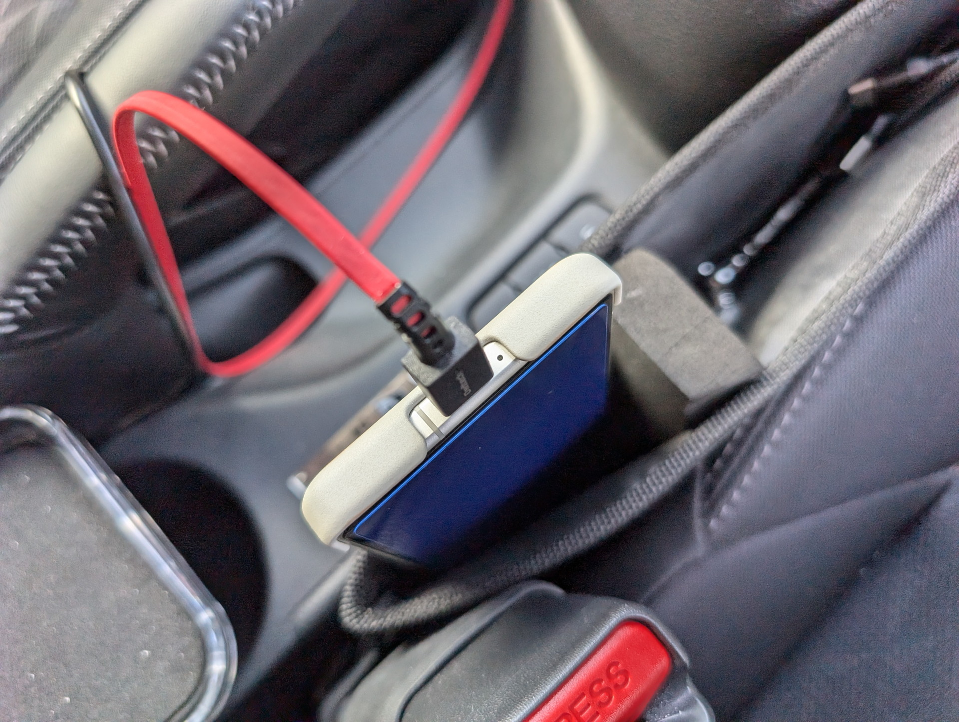 充電中はシート横のポケットに突っ込んでいる。このポケットも星光産業製で「EH-184 スキマポケット」。関係ありませんが前出のA/Cホルダーも使ってます。ケーブルはオウルテックの「katamaki」（これはType-Aモデル）