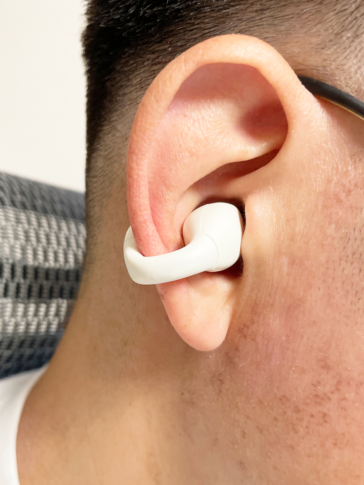 耳輪にひっかけて、スピーカー部分を耳の穴に近づけて使用します。ぐっと押し込まれているように見えますが外の音も普通に聞こえます。