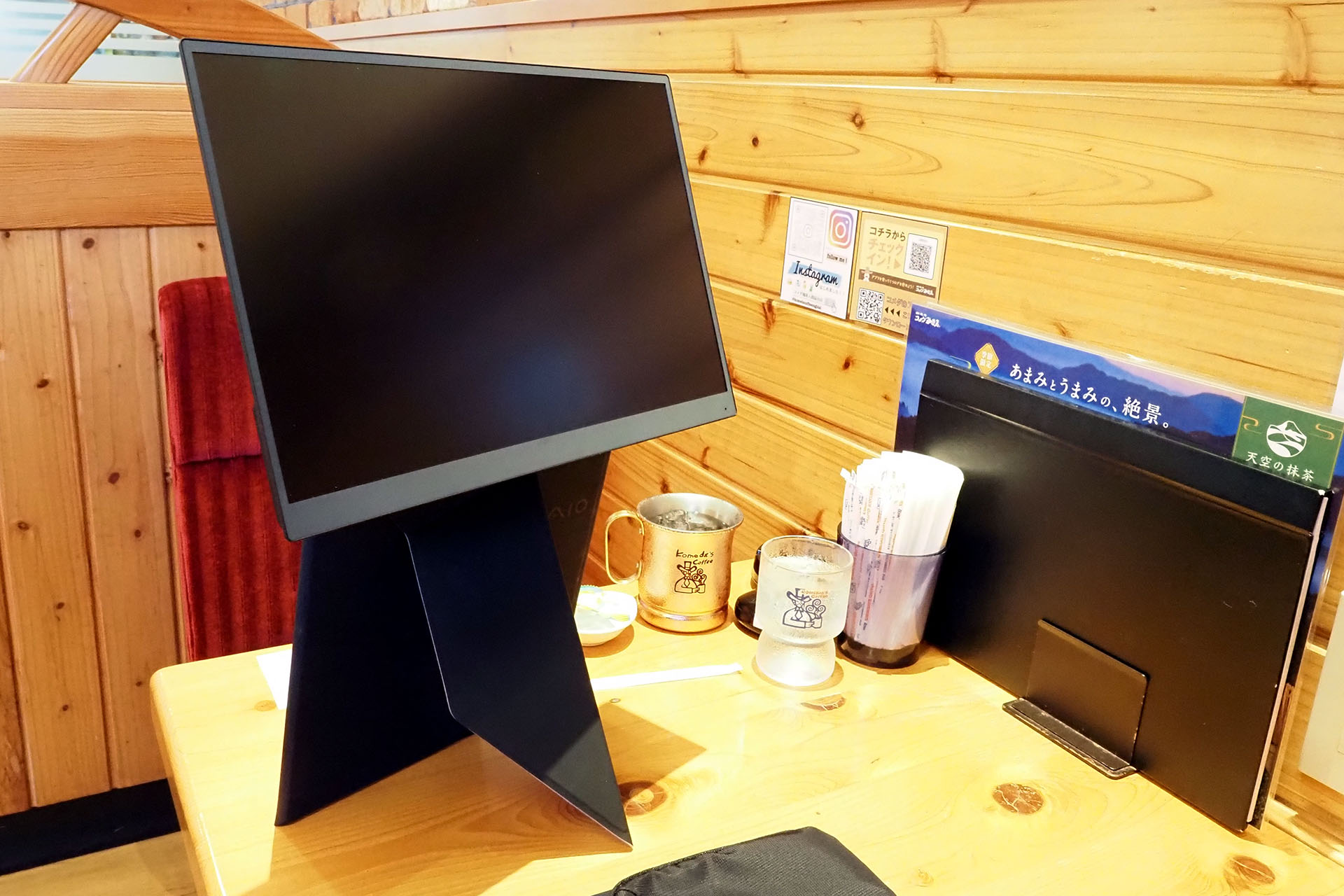 カバースタンドの下方はこんな状態。不安定ではないものの、重心が高くディスプレイ自体も軽いので、ディスプレイを服などに引っ掛けると倒れる可能性がある。この状態でディスプレイが右に倒れたら大惨事ですな。ディスプレイ背面が壁や窓の席だと不安感が少ないだろう。