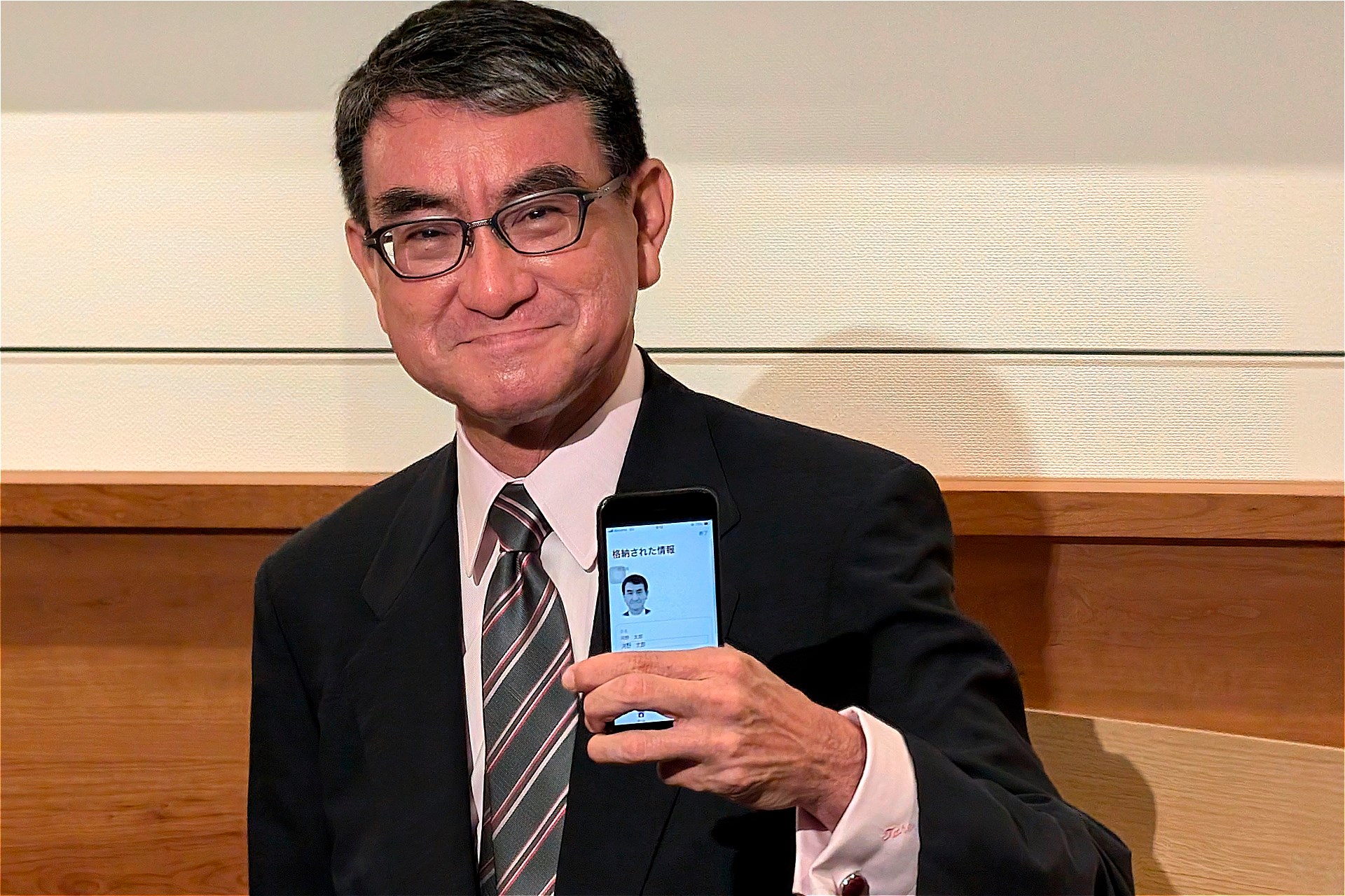 指で自身の個人情報を隠しながら、撮影に応じる河野大臣